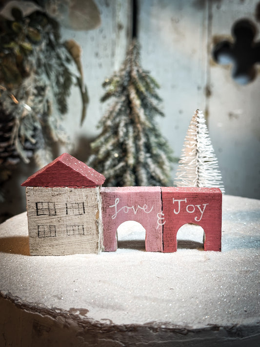 A pretty vintage German Erzgebirge Putz wooden village house painted with a Christmas quote