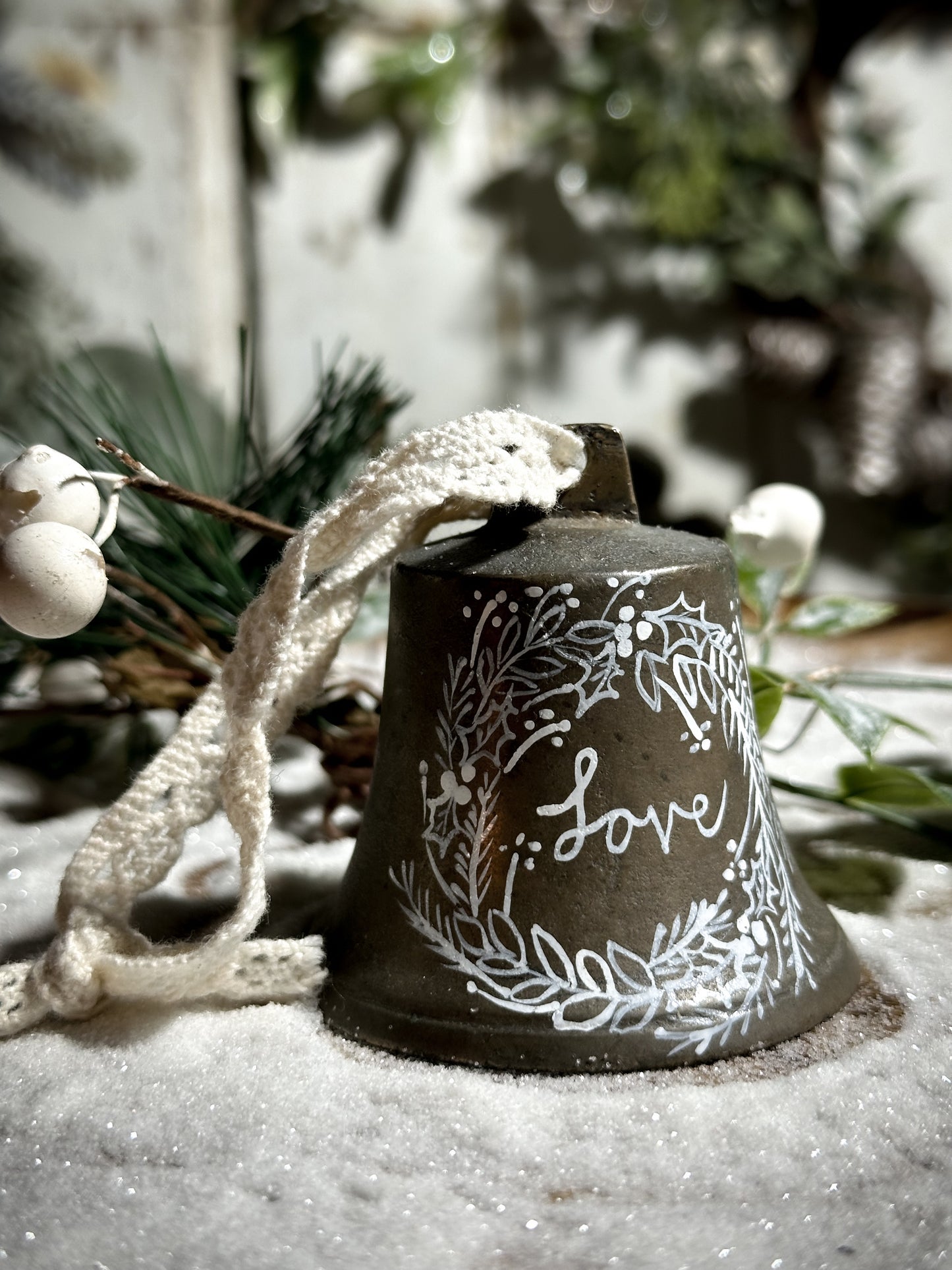 A vintage brass bell with a hand painted quote