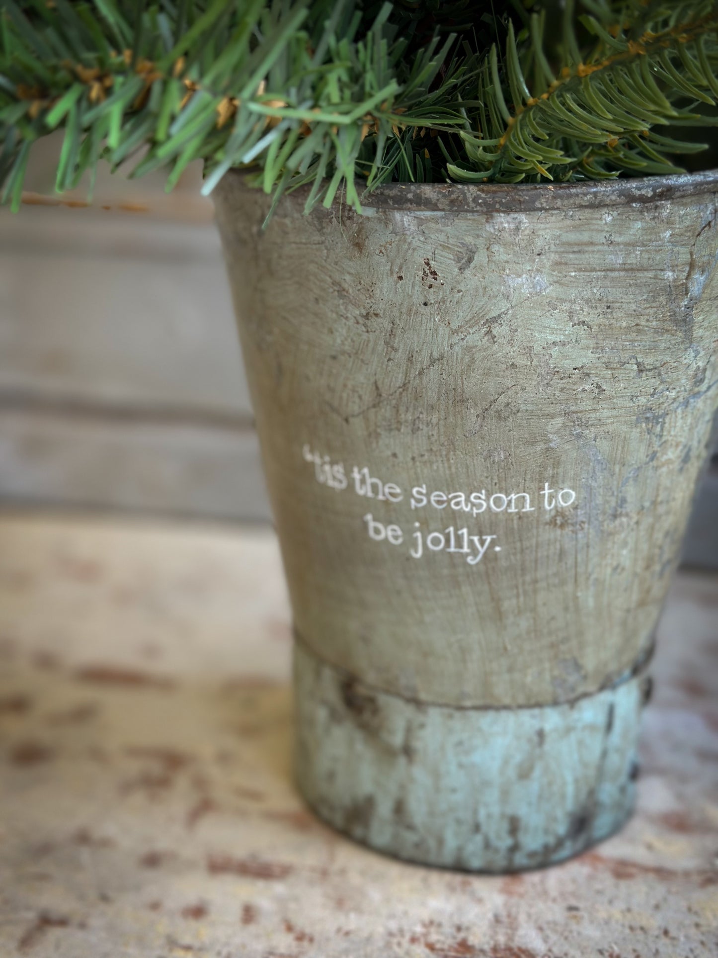 A Recycled Metal Mini Christmas Tree Bucket With A Hand Painted Quote