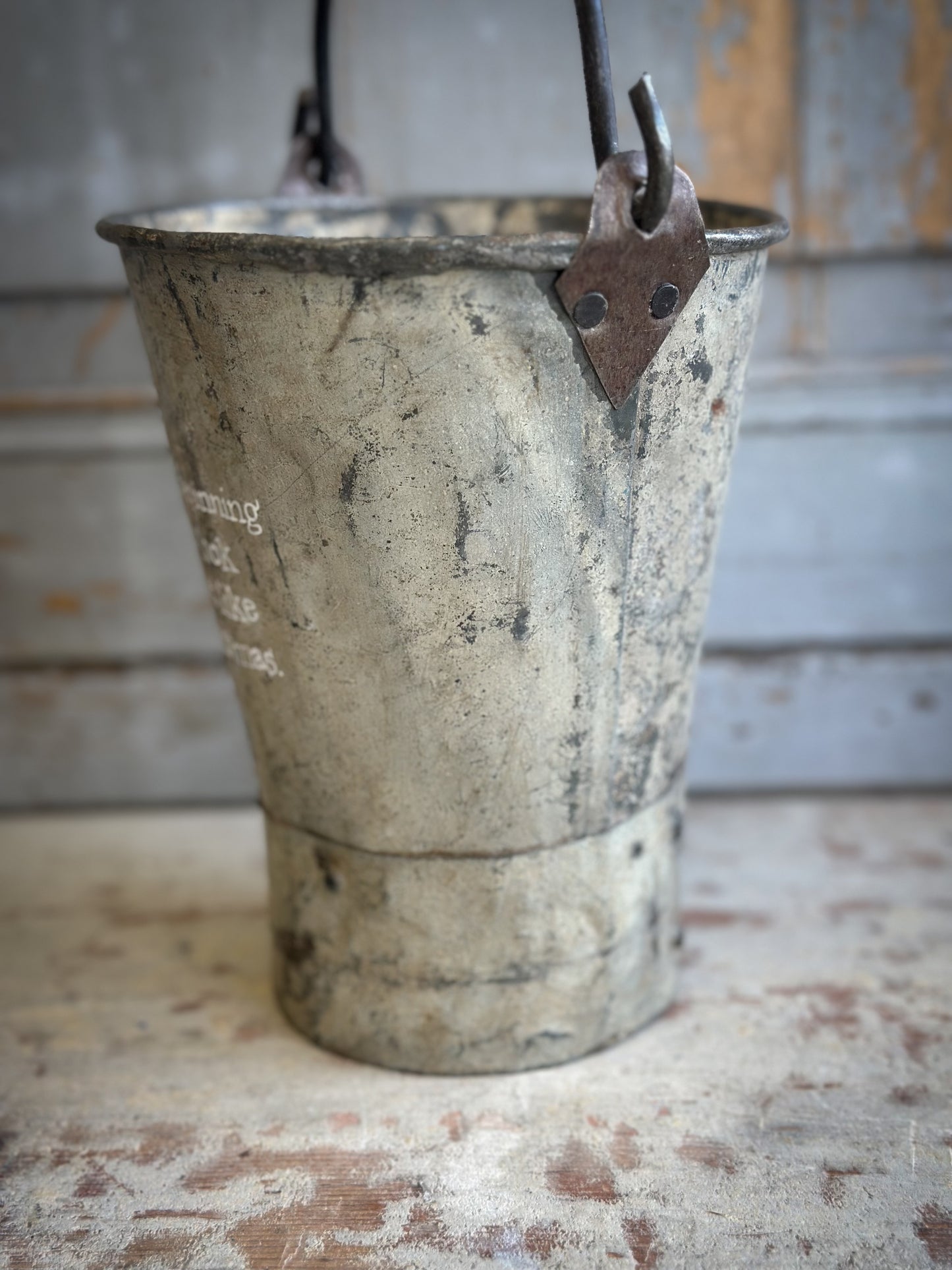 A Recycled Metal Mini Christmas Tree Bucket With A Hand Painted Quote