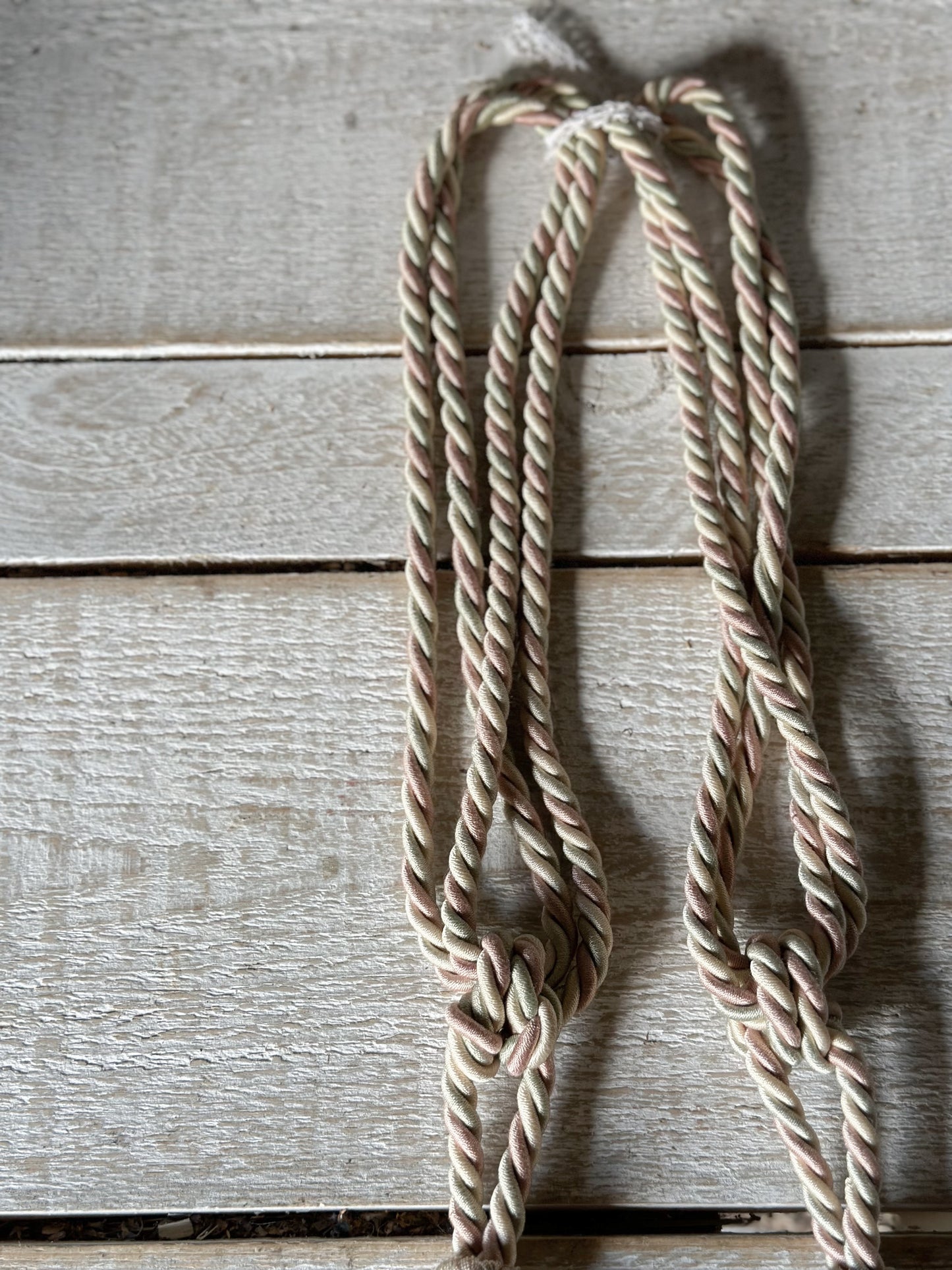 A pair of pretty vintage pastel pink, sage green and ivory curtain tie backs