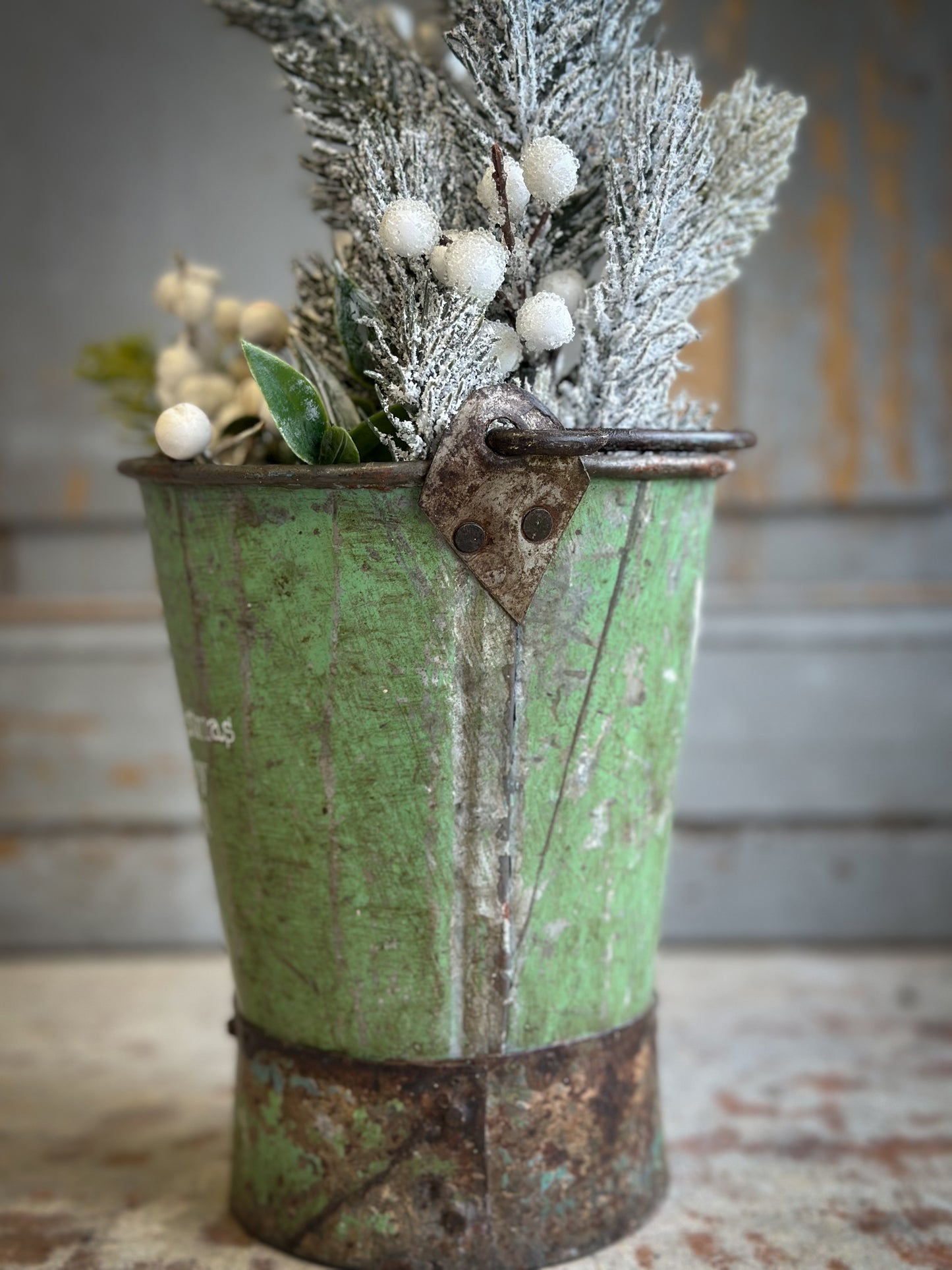 A Recycled Metal Mini Christmas Tree Bucket With A Hand Painted Quote