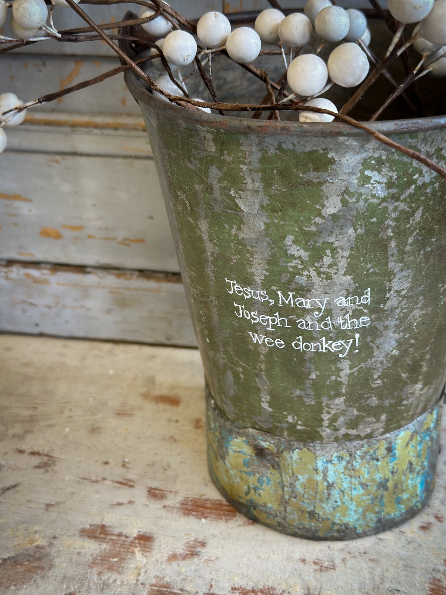 A Recycled Metal Mini Christmas Tree Bucket With A Hand Painted Quote