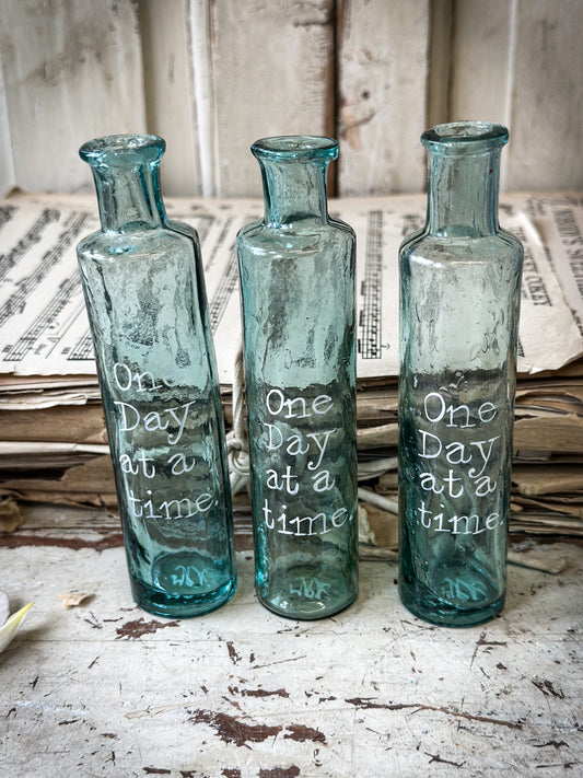 A beautiful Victorian cylinder bottle painted with a quote “One Day at a time”