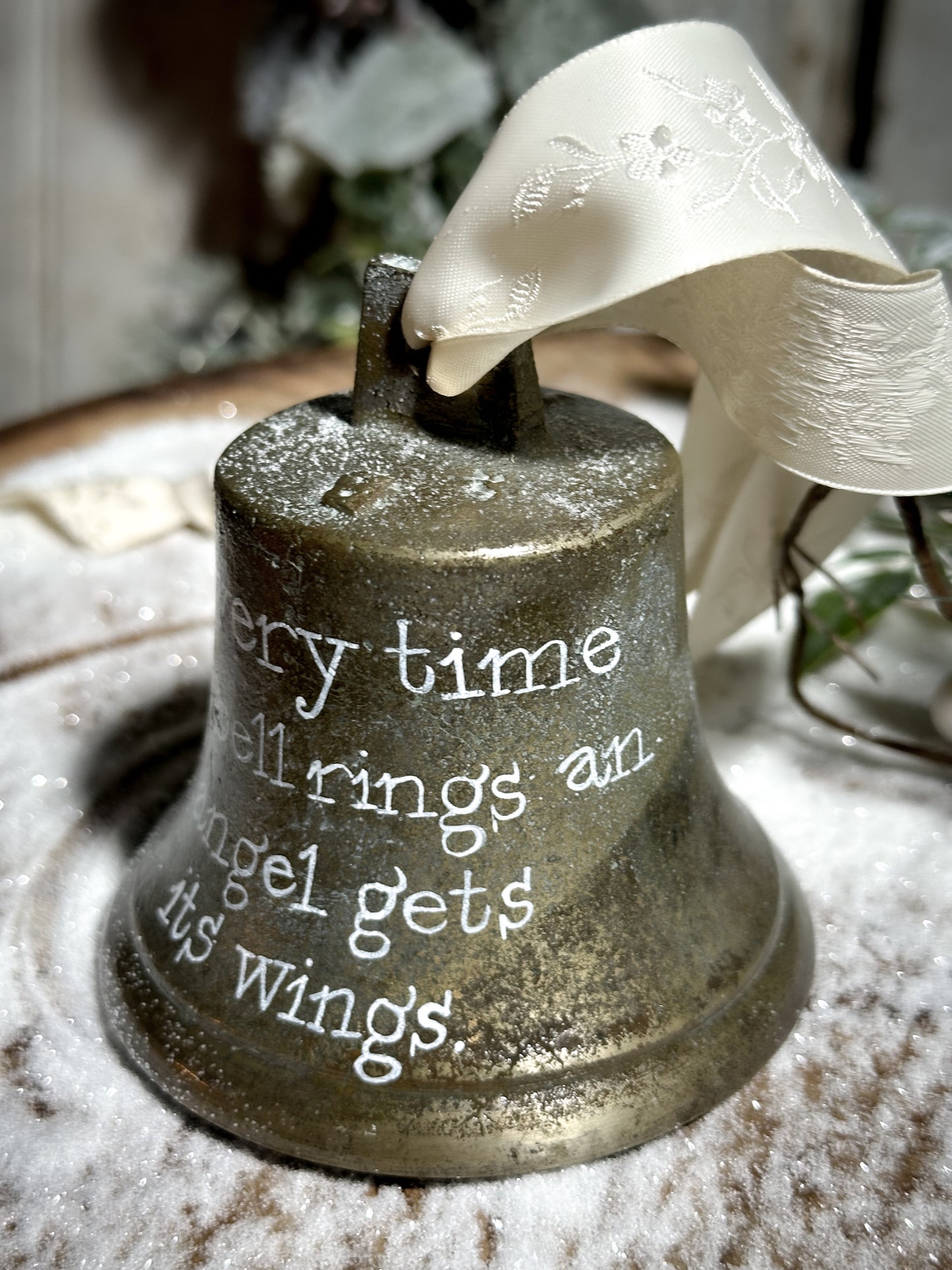 A vintage brass bell with a hand painted quote