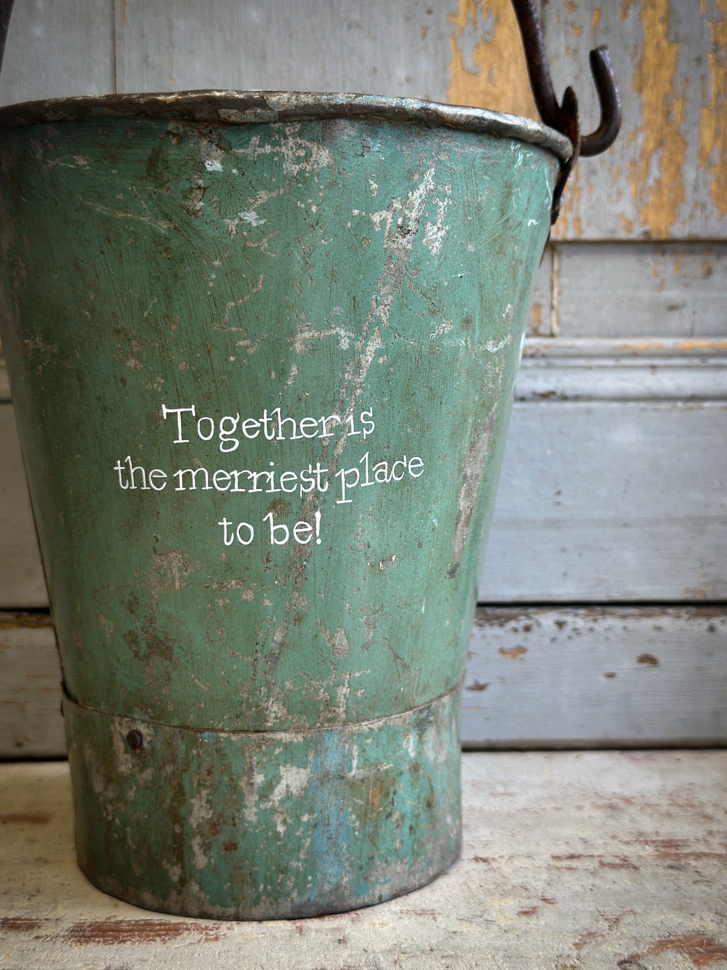 A Recycled Metal Mini Christmas Tree Bucket With A Hand Painted Quote