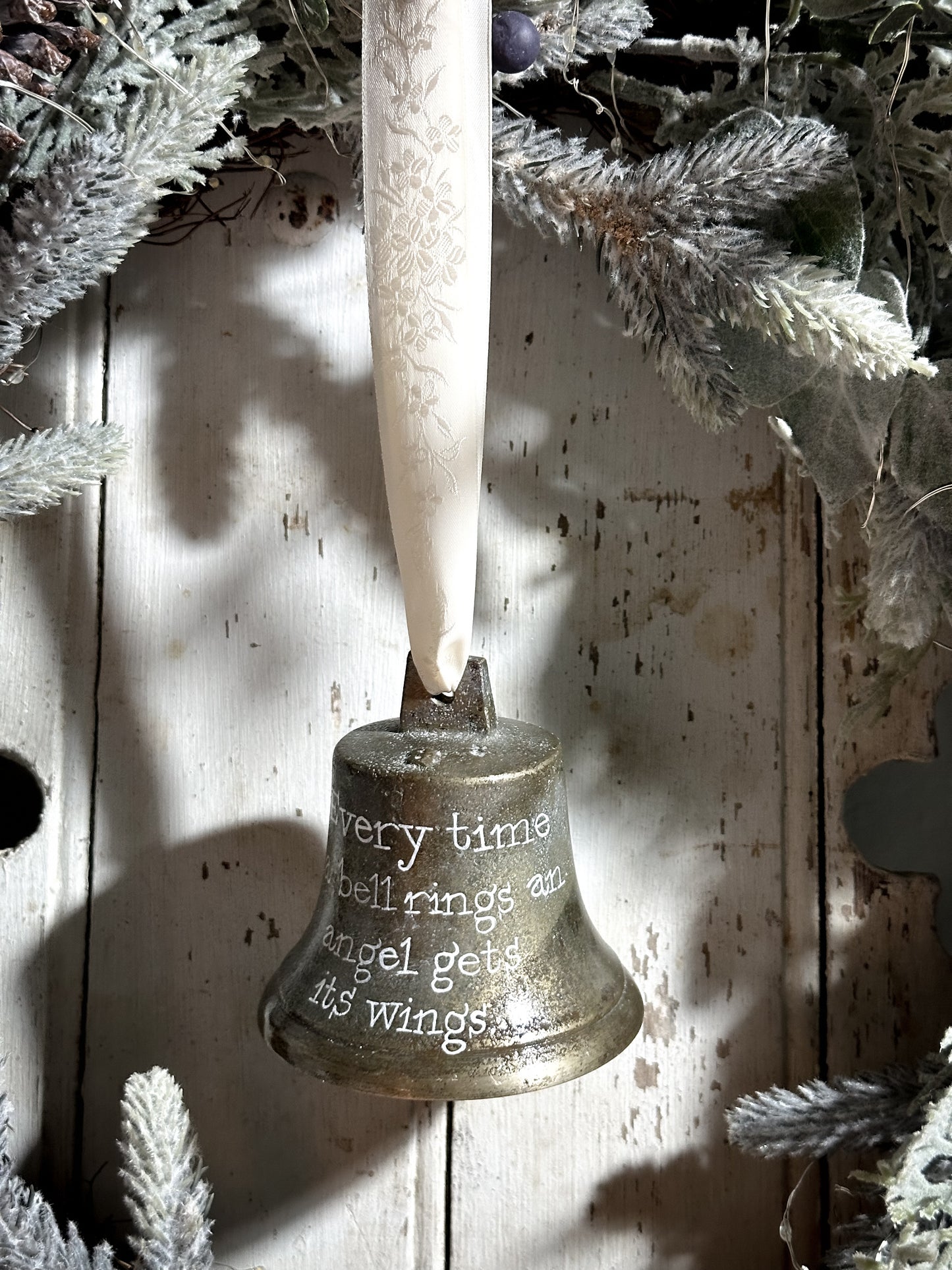 A vintage brass bell with a hand painted quote