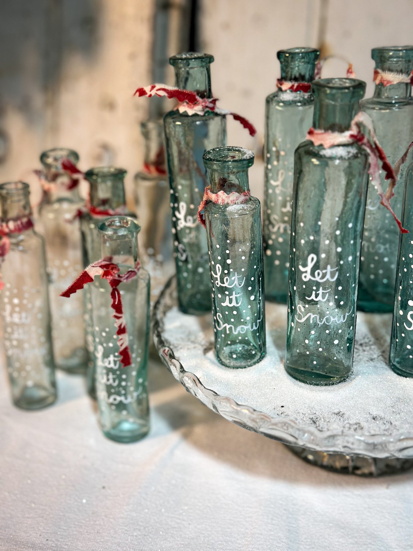 A beautiful Victorian cylinder bottle painted with a Christmas quote “Let it Snow”