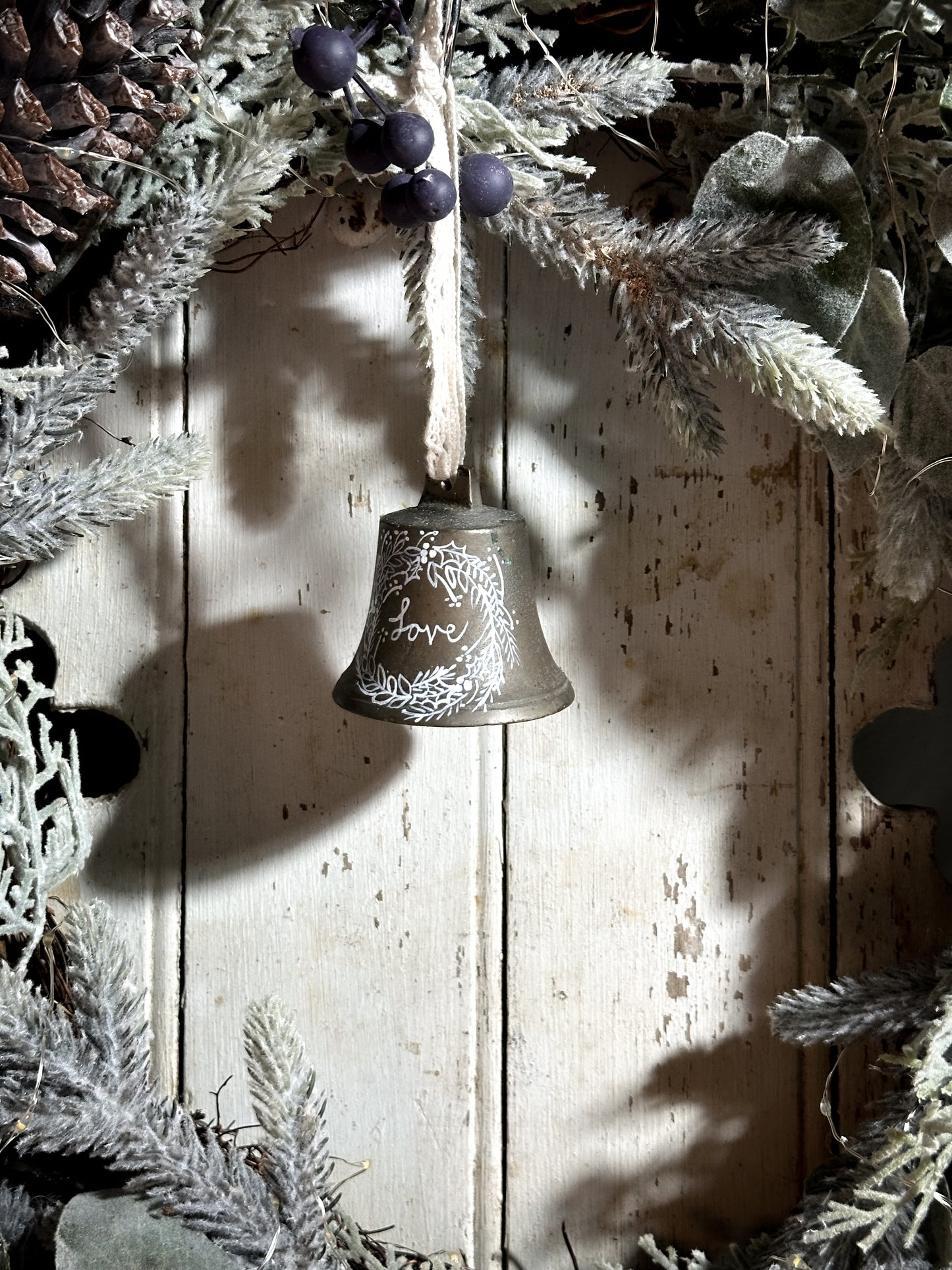 A vintage brass bell with a hand painted quote