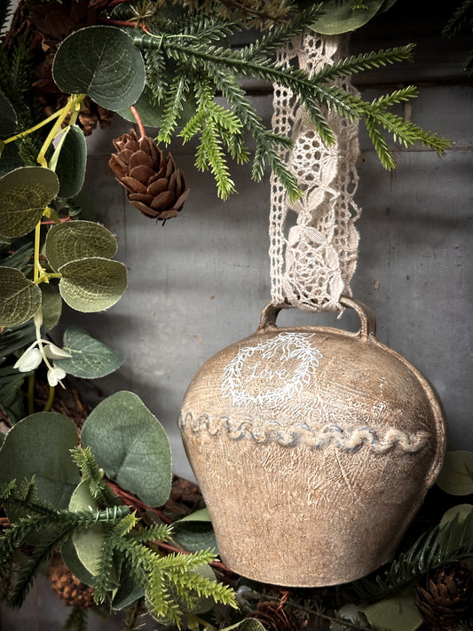 A Large Vintage Painted Cow Bell With a Hand Painted Quote