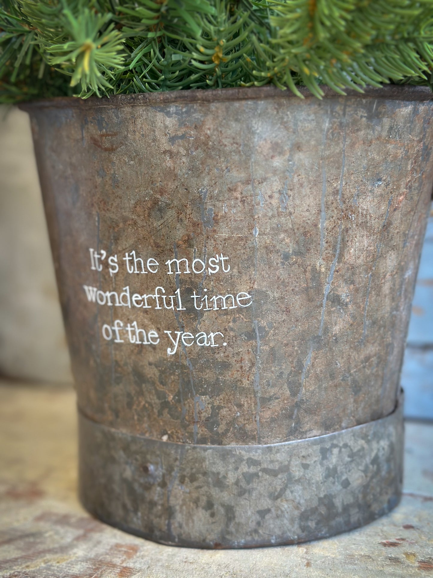 A Recycled Metal Small Christmas Tree Bucket With A Hand Painted Quote