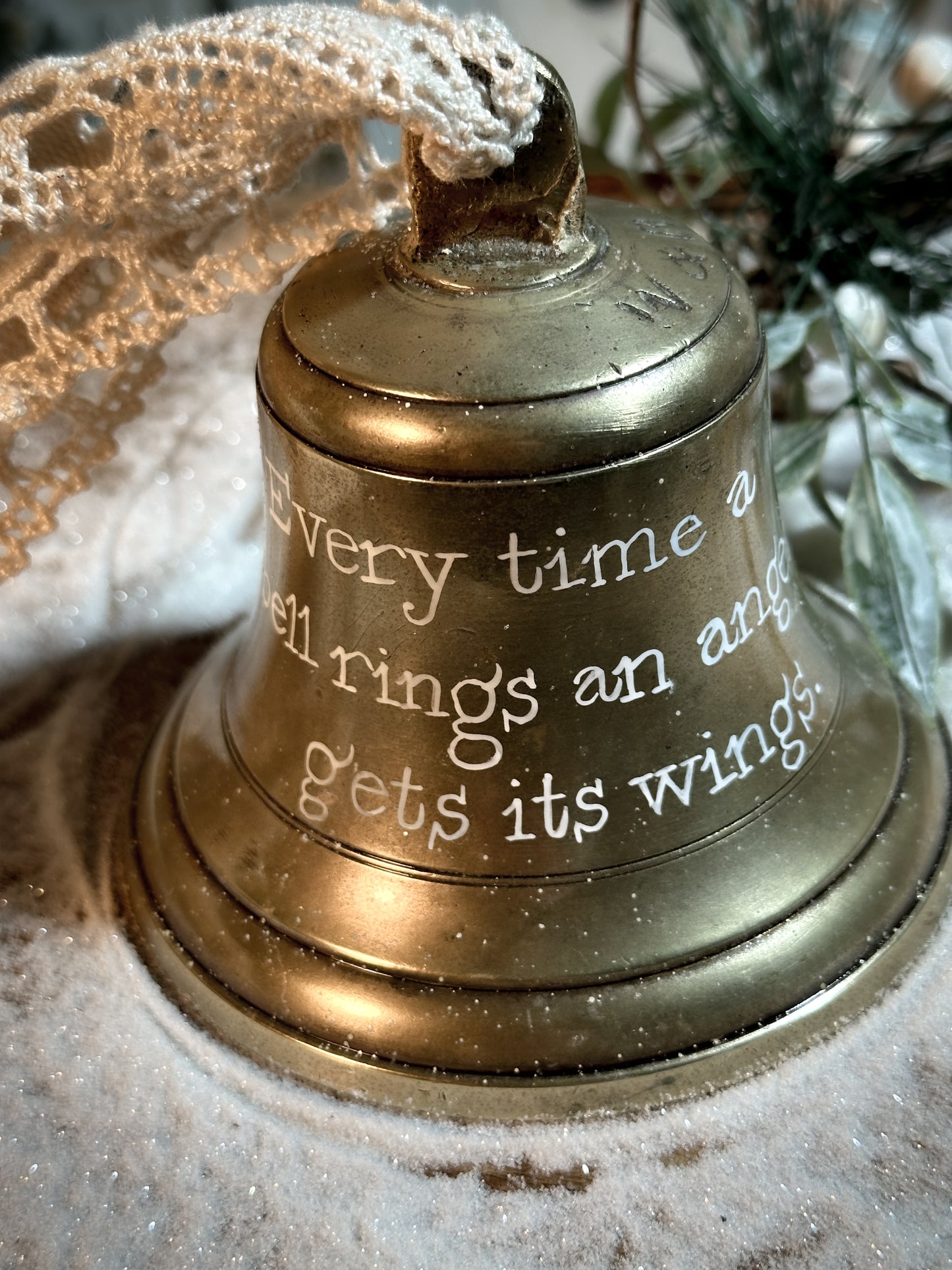 A vintage brass bell with a hand painted quote