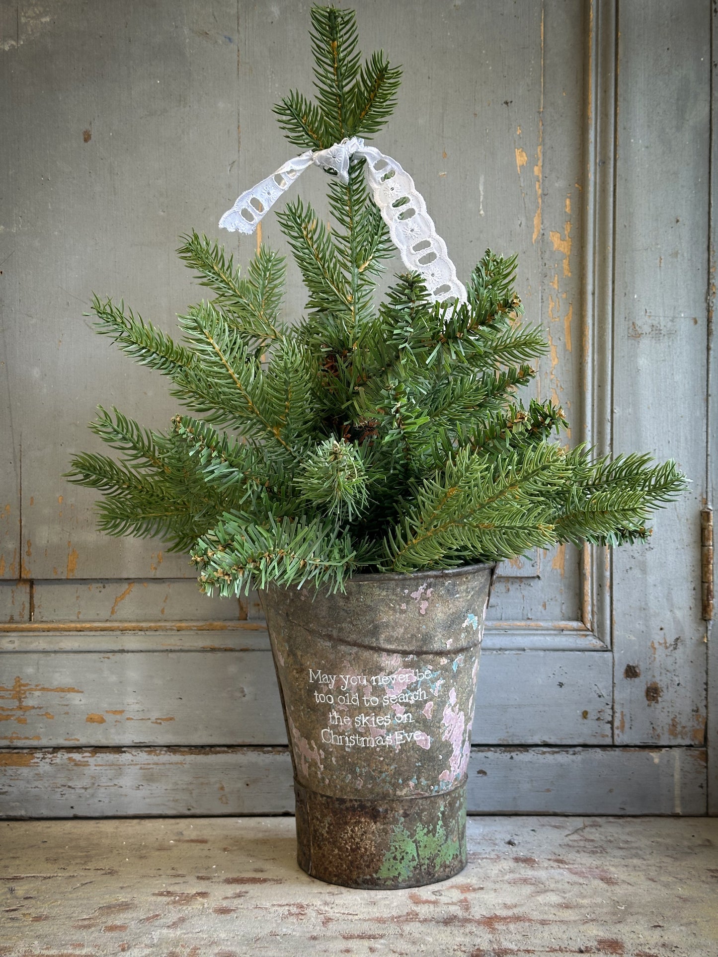 A Recycled Metal Mini Christmas Tree Bucket With A Hand Painted Quote