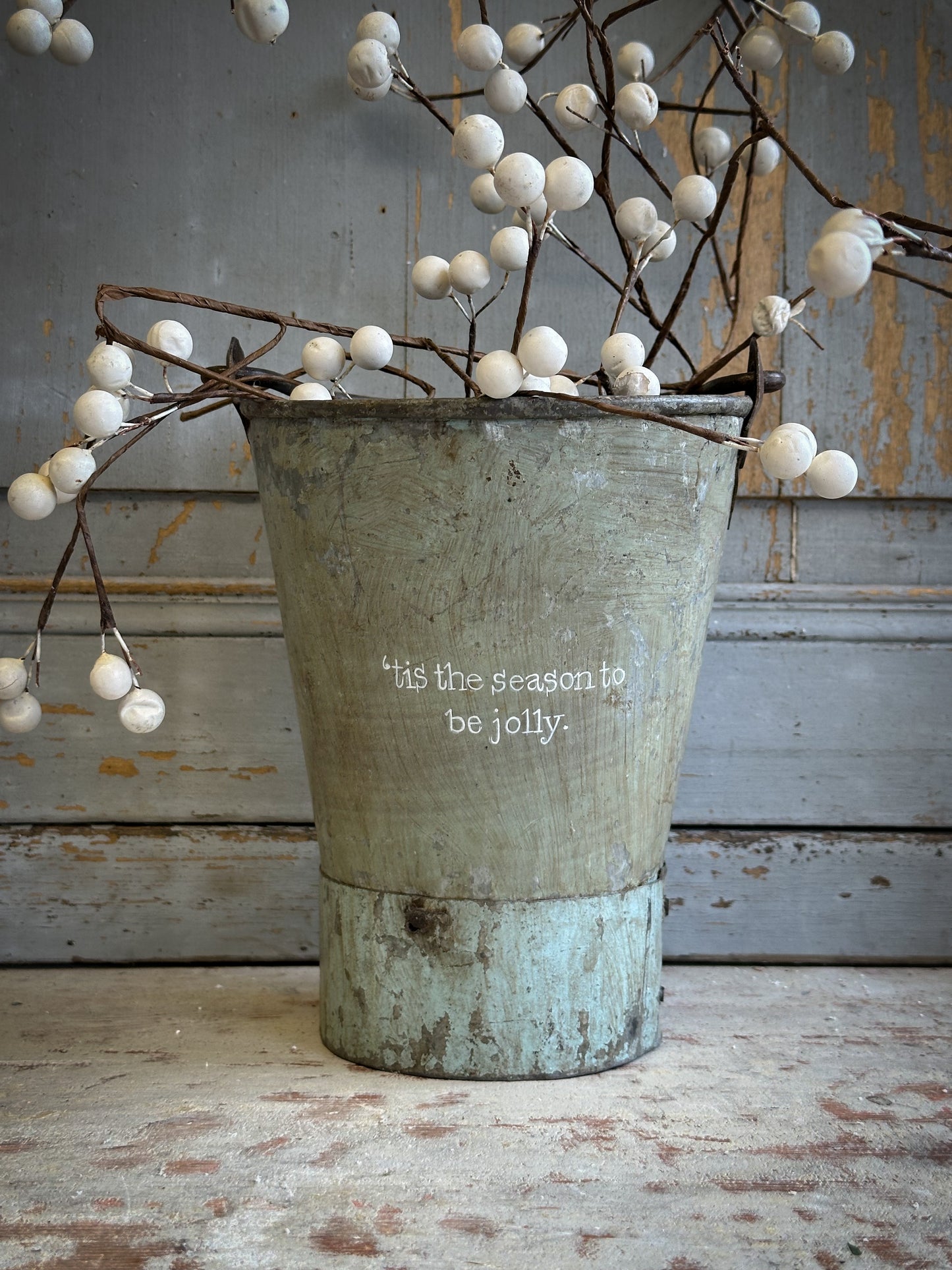 A Recycled Metal Mini Christmas Tree Bucket With A Hand Painted Quote