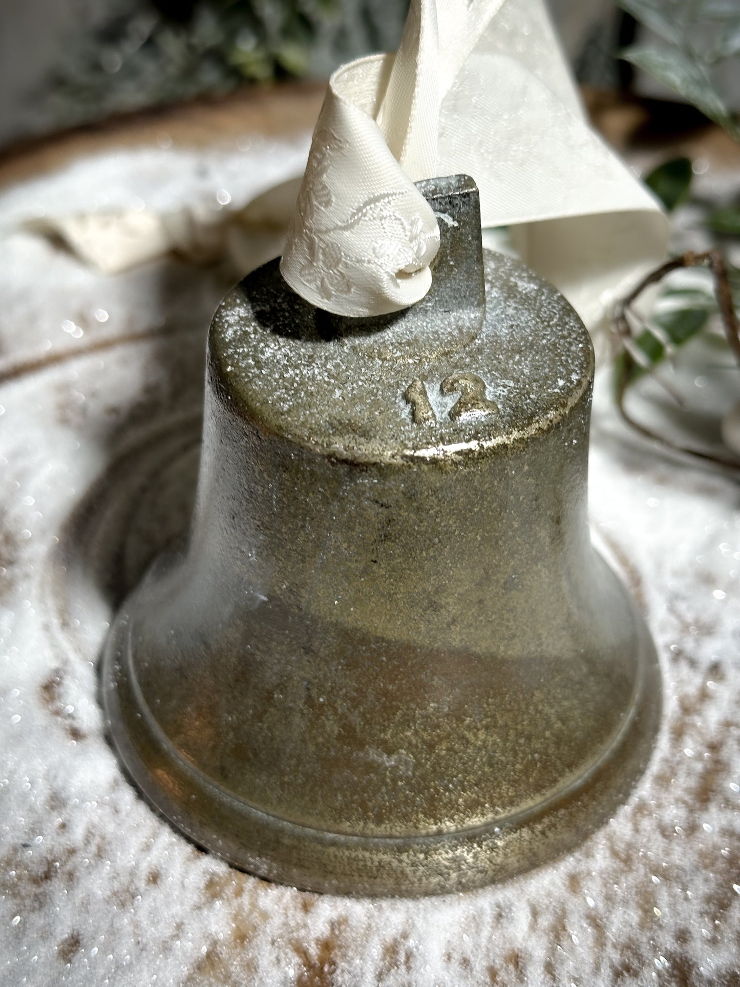 A vintage brass bell with a hand painted quote