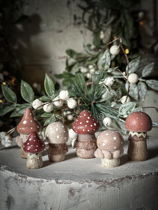 A set of six wooden hand painted and trimmed Christmas village mushrooms