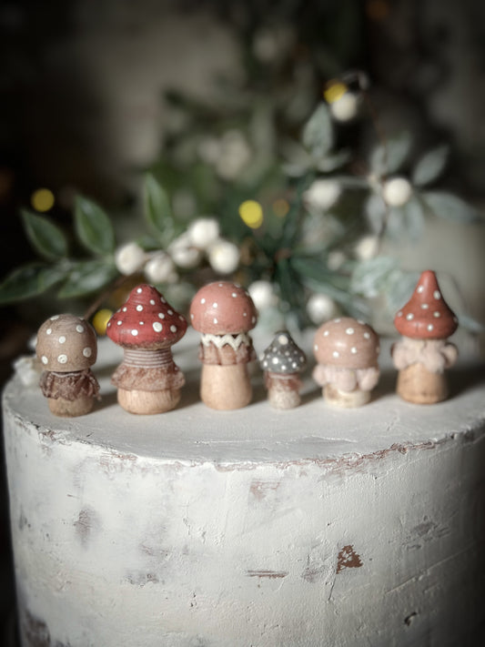 A set of six wooden hand painted and trimmed Christmas village toadstools