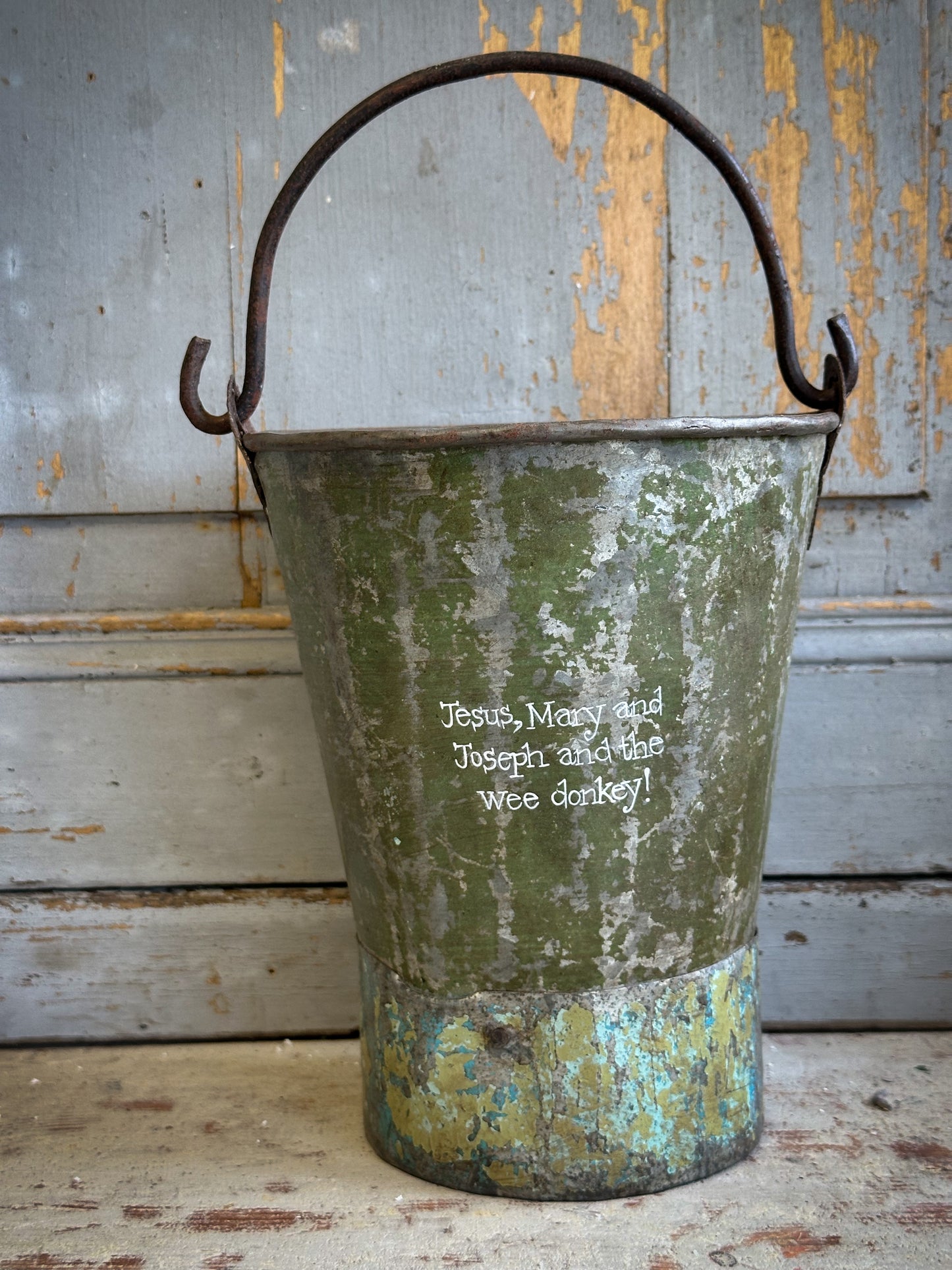 A Recycled Metal Mini Christmas Tree Bucket With A Hand Painted Quote