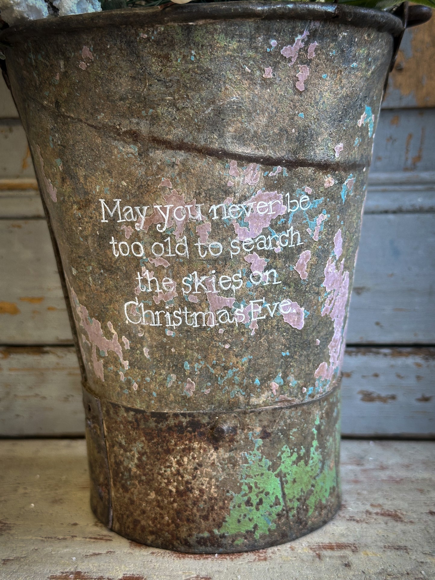 A Recycled Metal Mini Christmas Tree Bucket With A Hand Painted Quote