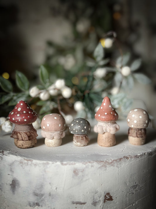 A set of five wooden hand painted and trimmed Christmas village toadstools