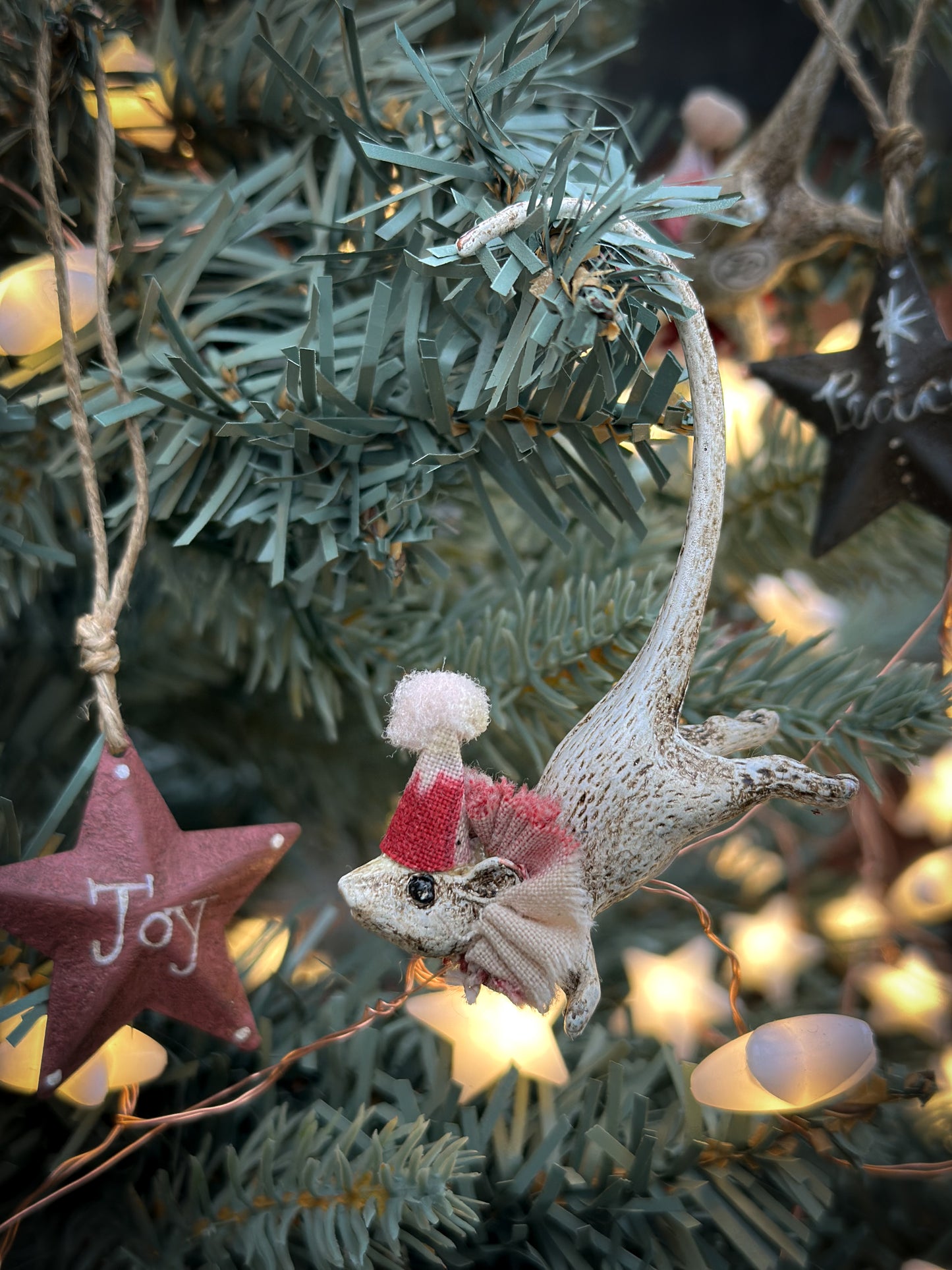 A mini tin barn star pink decoration hand painted with “Joy”