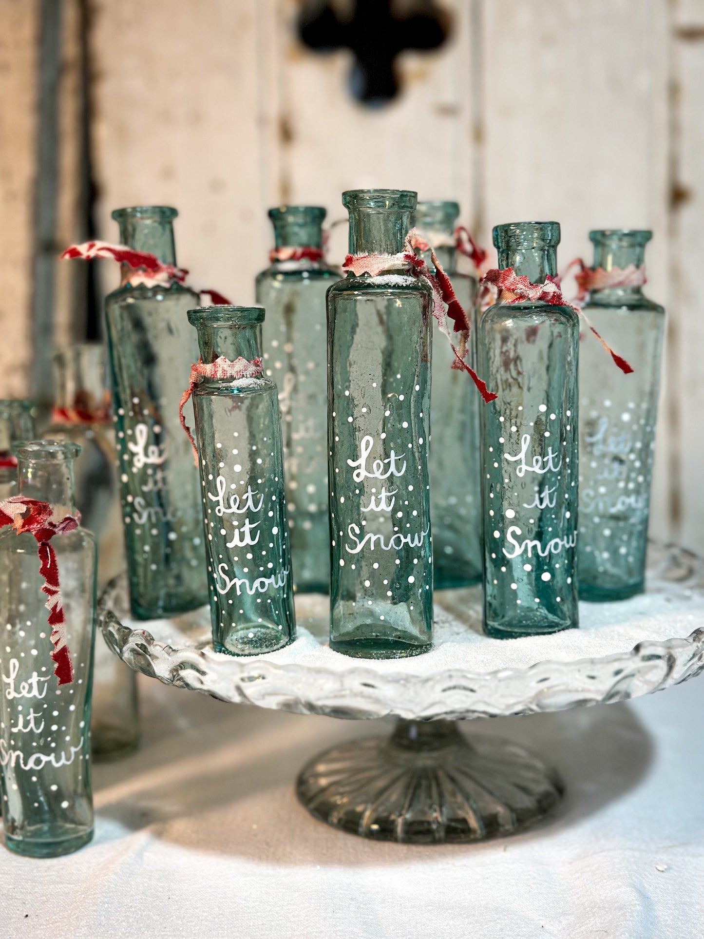 A beautiful Victorian cylinder bottle painted with a Christmas quote “Let it Snow”