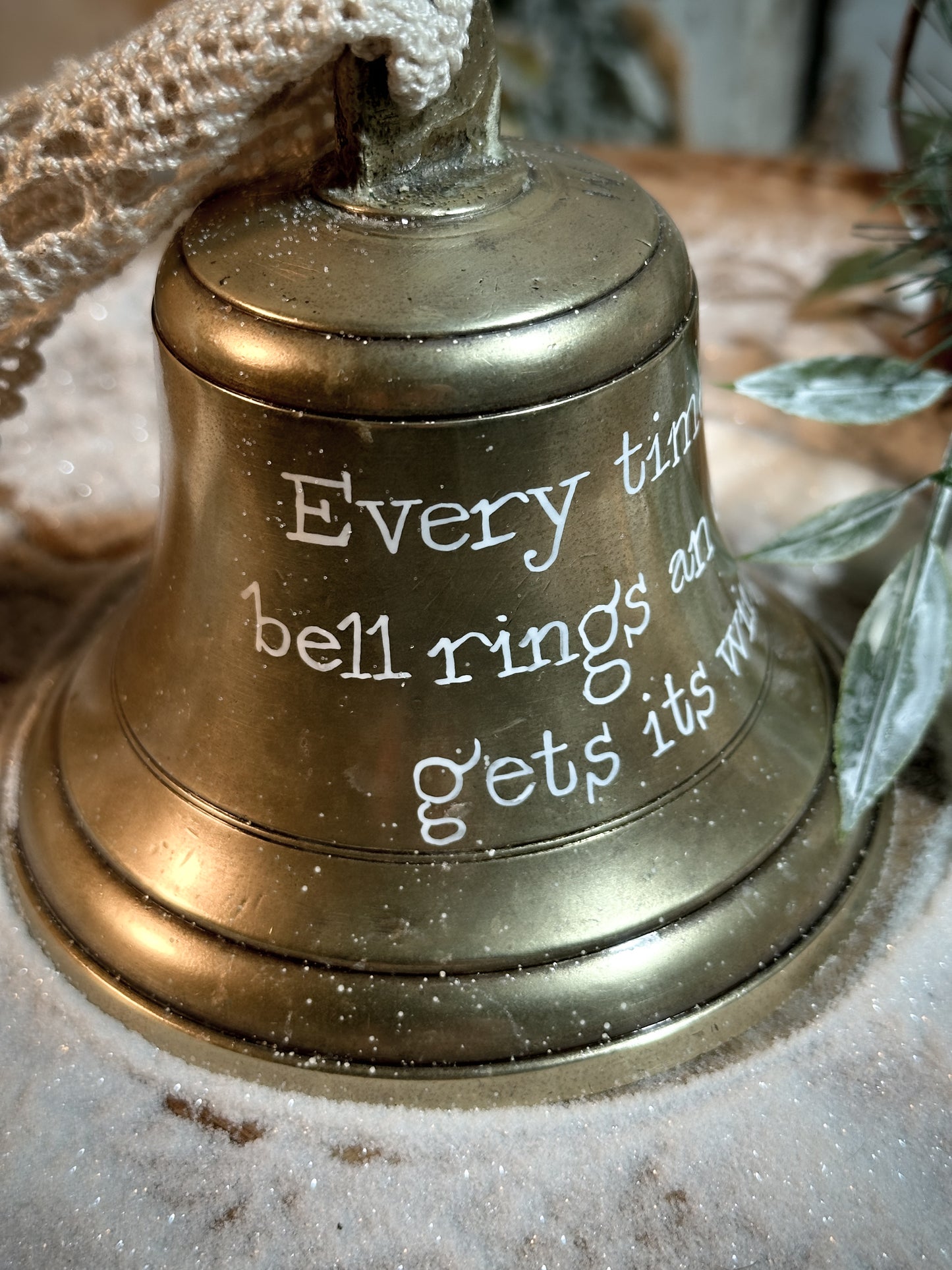 A vintage brass bell with a hand painted quote