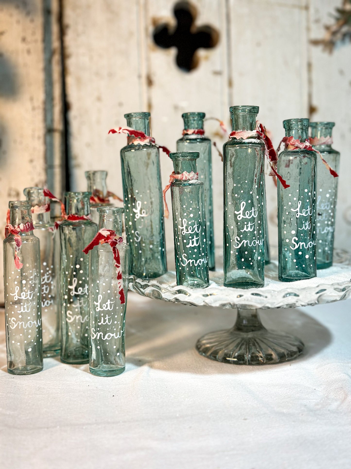 A beautiful Victorian cylinder bottle painted with a Christmas quote “Let it Snow”