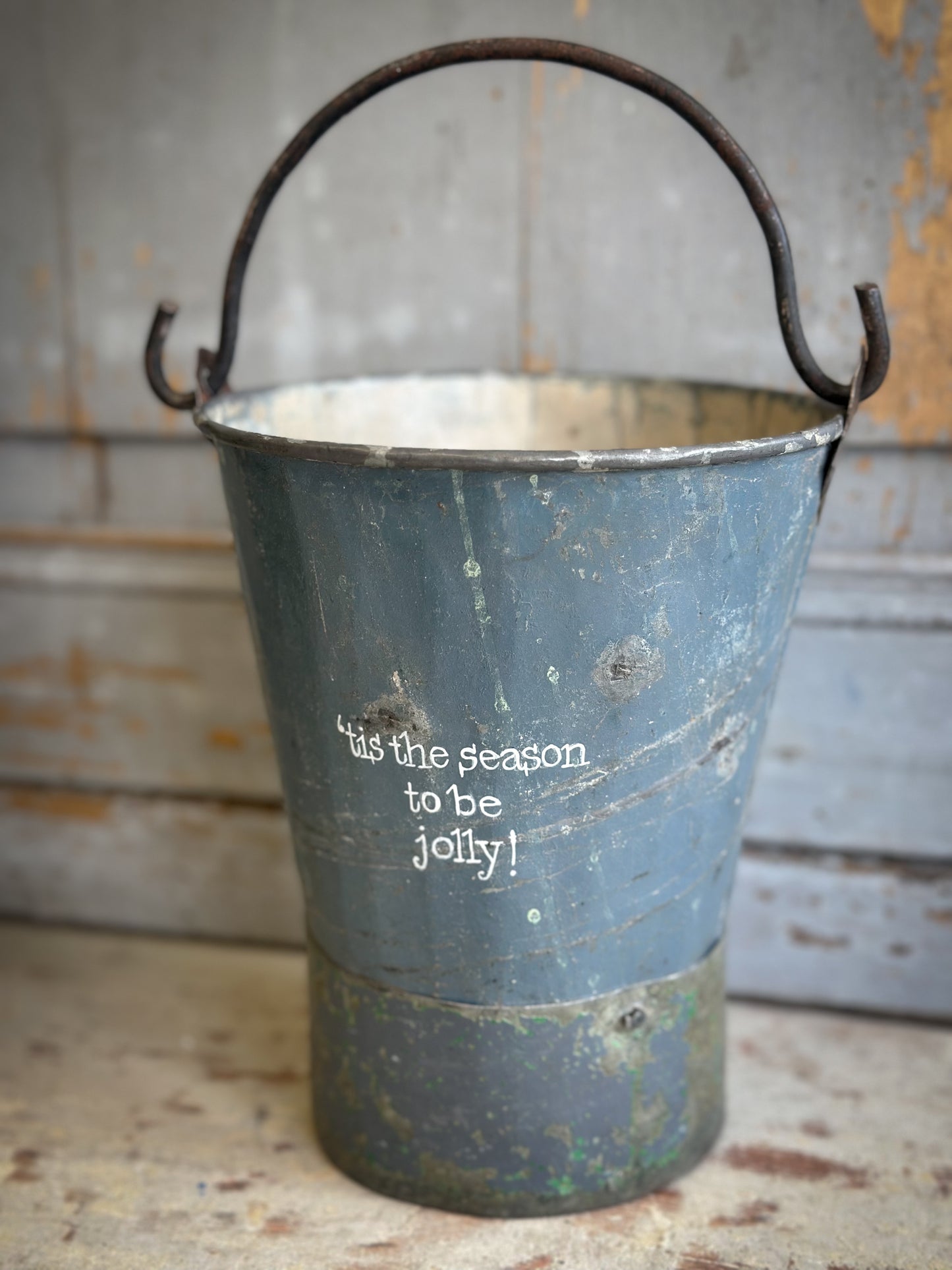 A Recycled Metal Mini Christmas Tree Bucket With A Hand Painted Quote