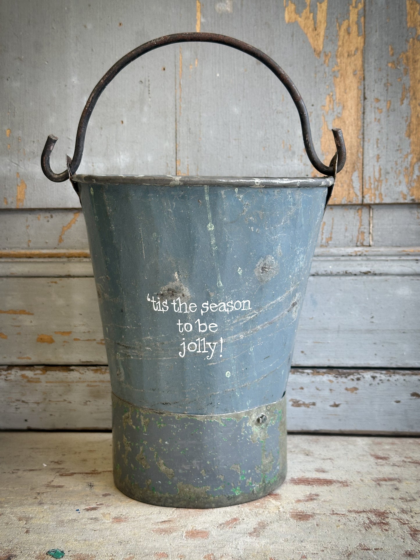 A Recycled Metal Mini Christmas Tree Bucket With A Hand Painted Quote