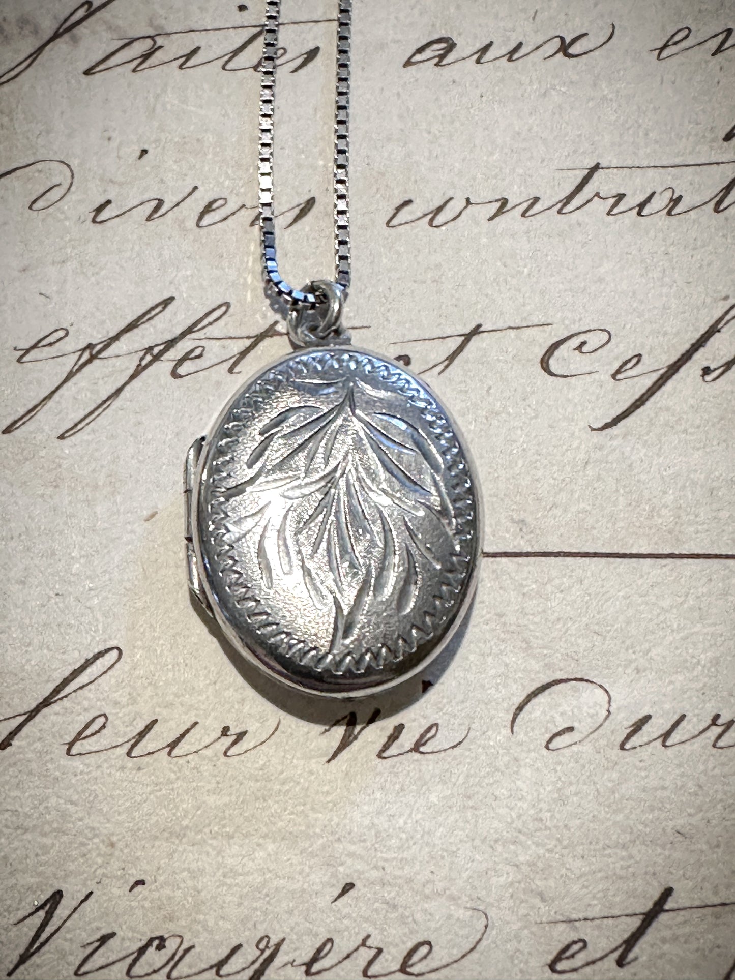 A pretty oval sterling silver vintage locket and chain