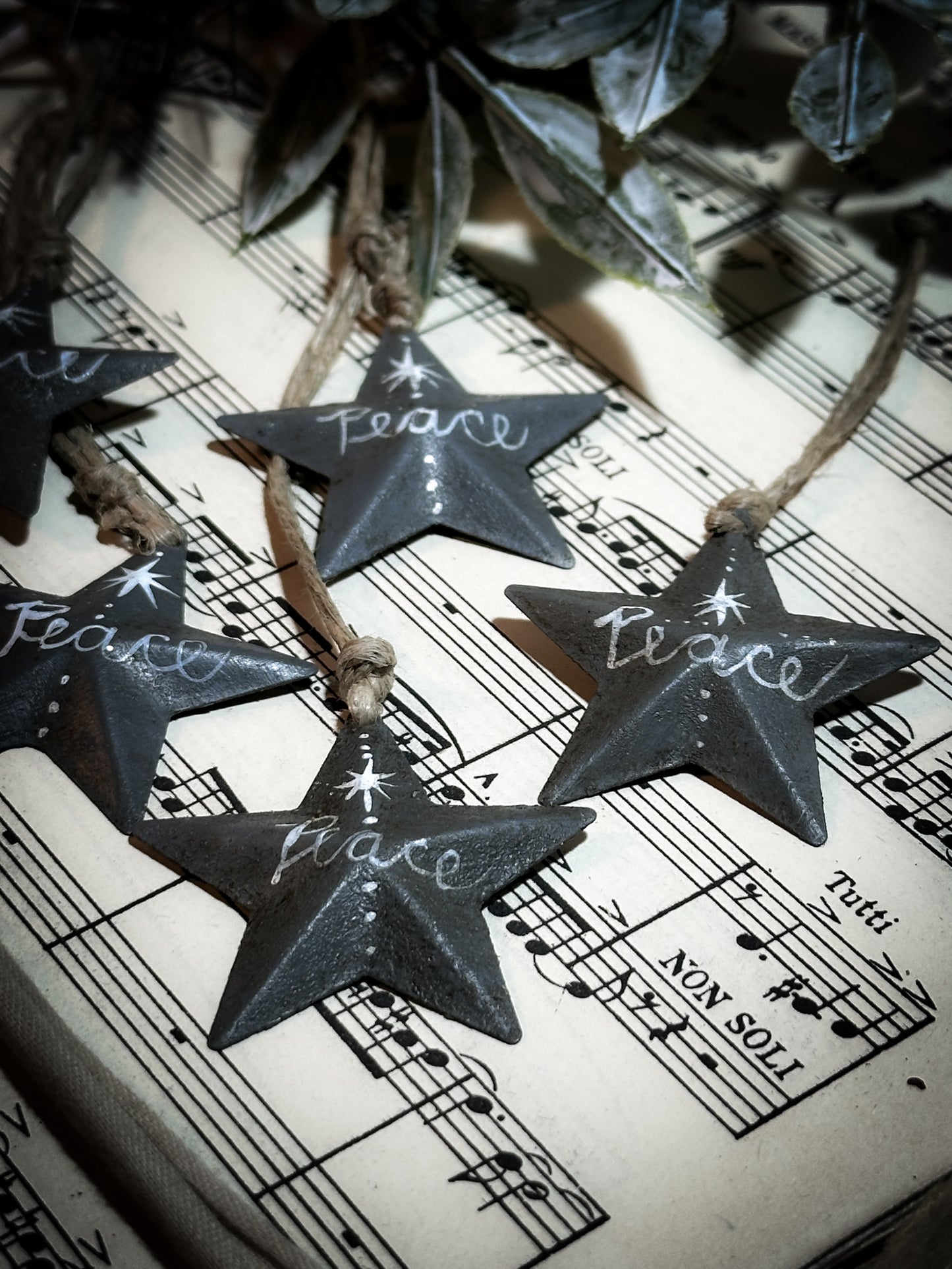 A mini tin barn star charcoal grey decoration hand painted with “Peace”