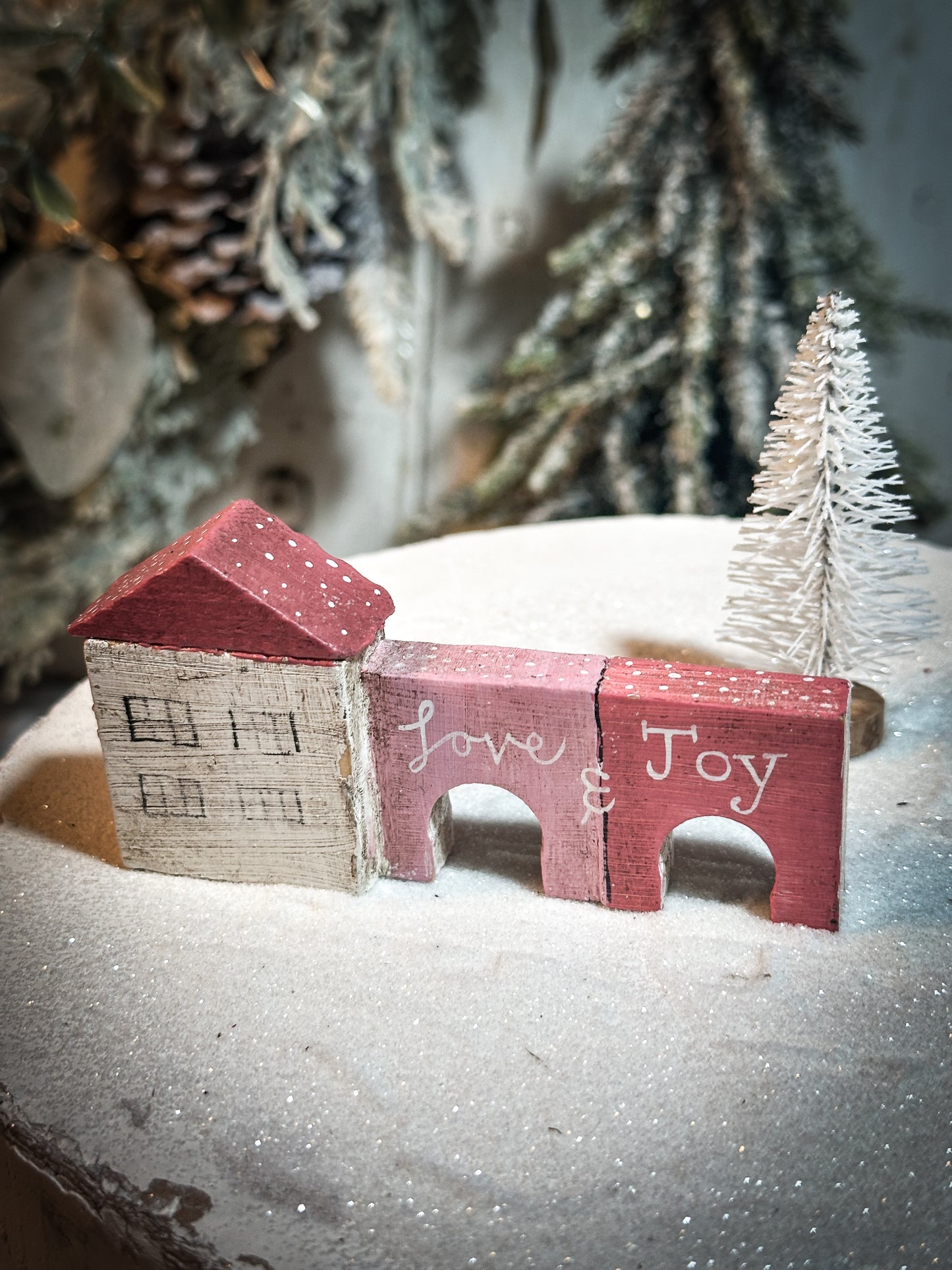 A pretty vintage German Erzgebirge Putz wooden village house painted with a Christmas quote