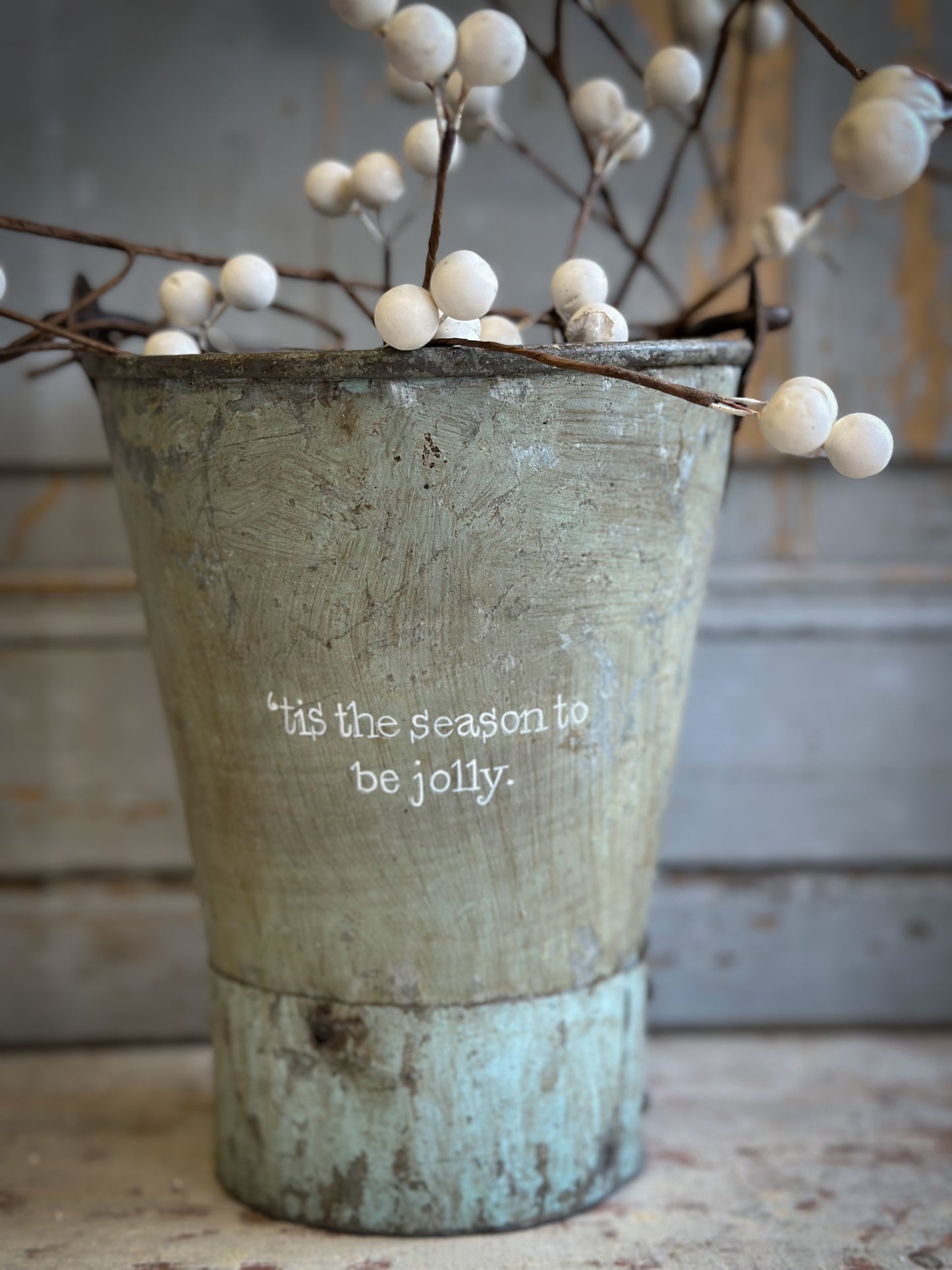 A Recycled Metal Mini Christmas Tree Bucket With A Hand Painted Quote