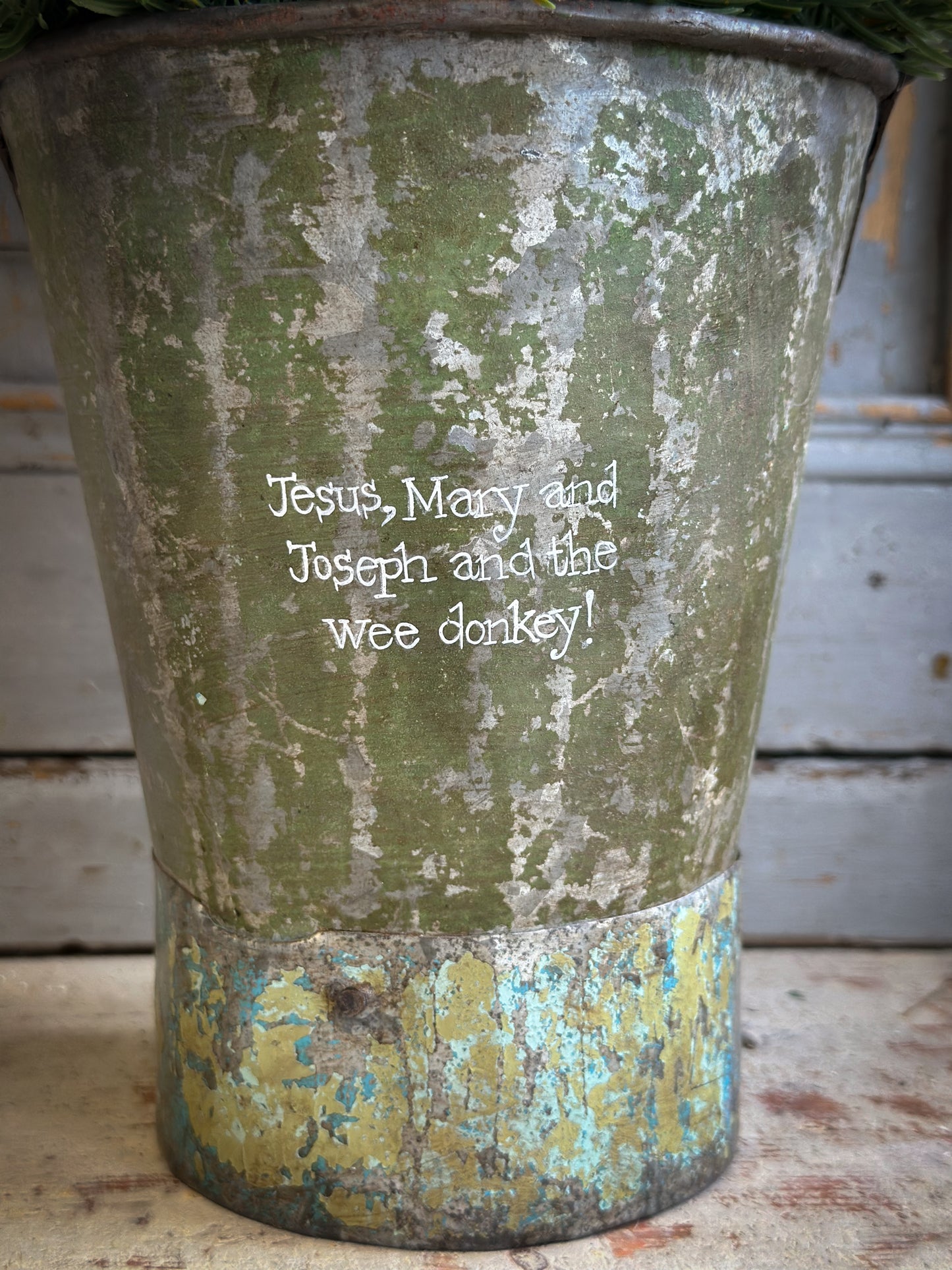 A Recycled Metal Mini Christmas Tree Bucket With A Hand Painted Quote