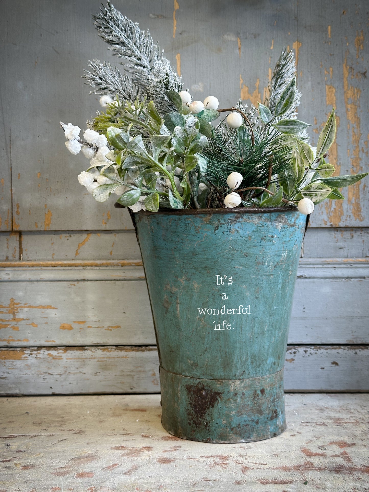 A Recycled Metal Mini Christmas Tree Bucket With A Hand Painted Quote