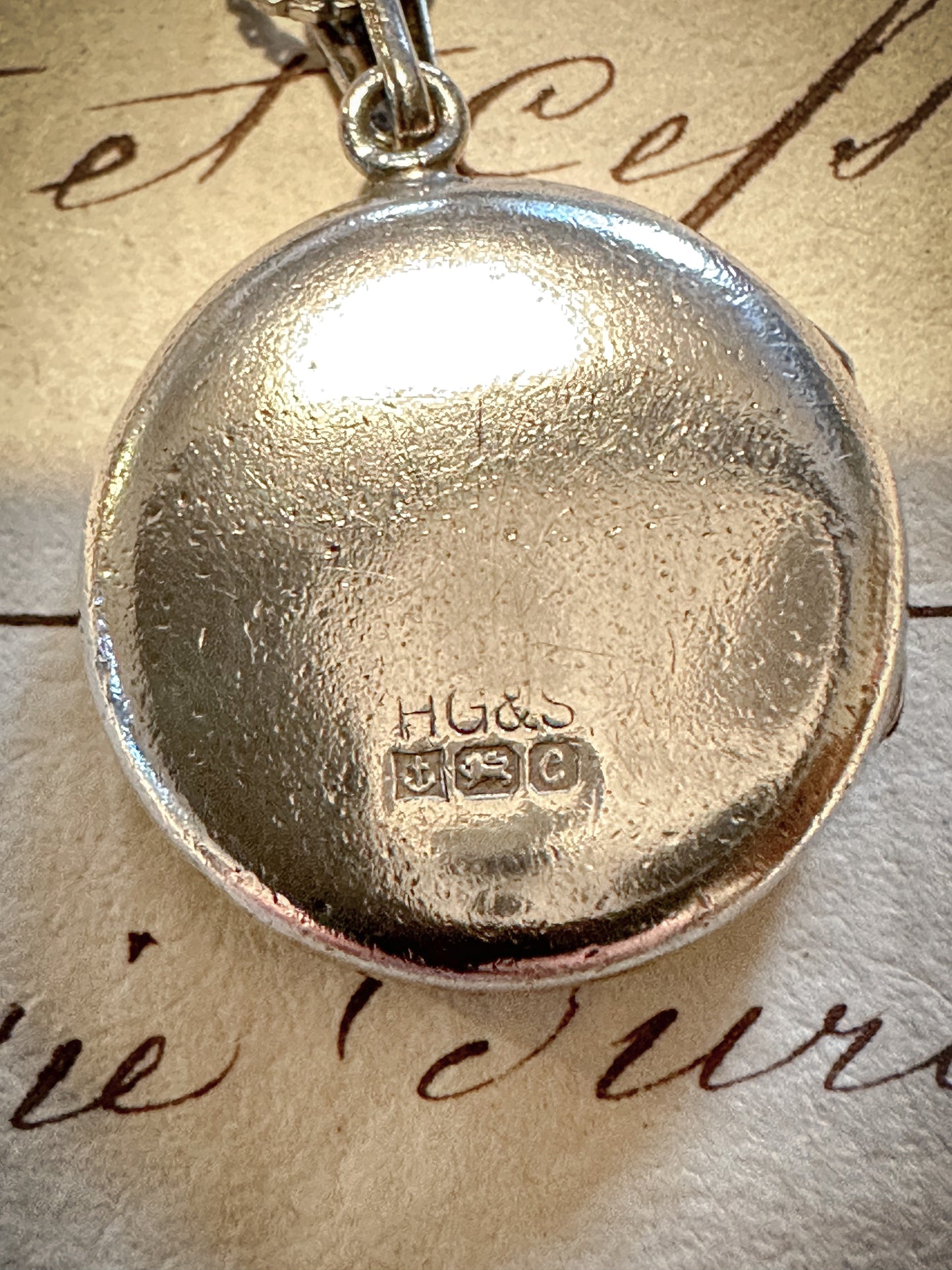 A pretty round silver hallmarked Birmingham, 1977 Henry Griffith & Son vintage locket and chain