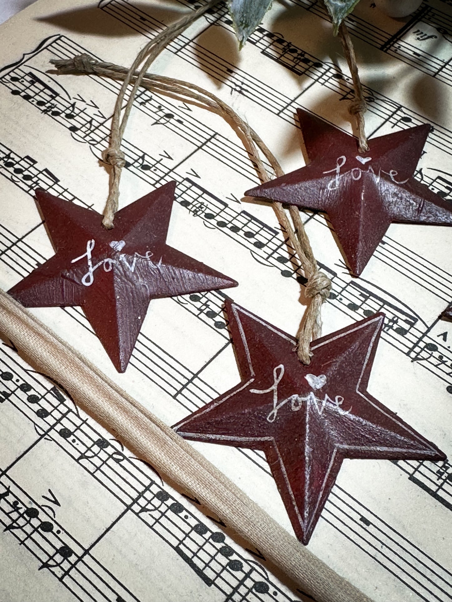 A mini tin barn star red decoration hand painted with “Love”