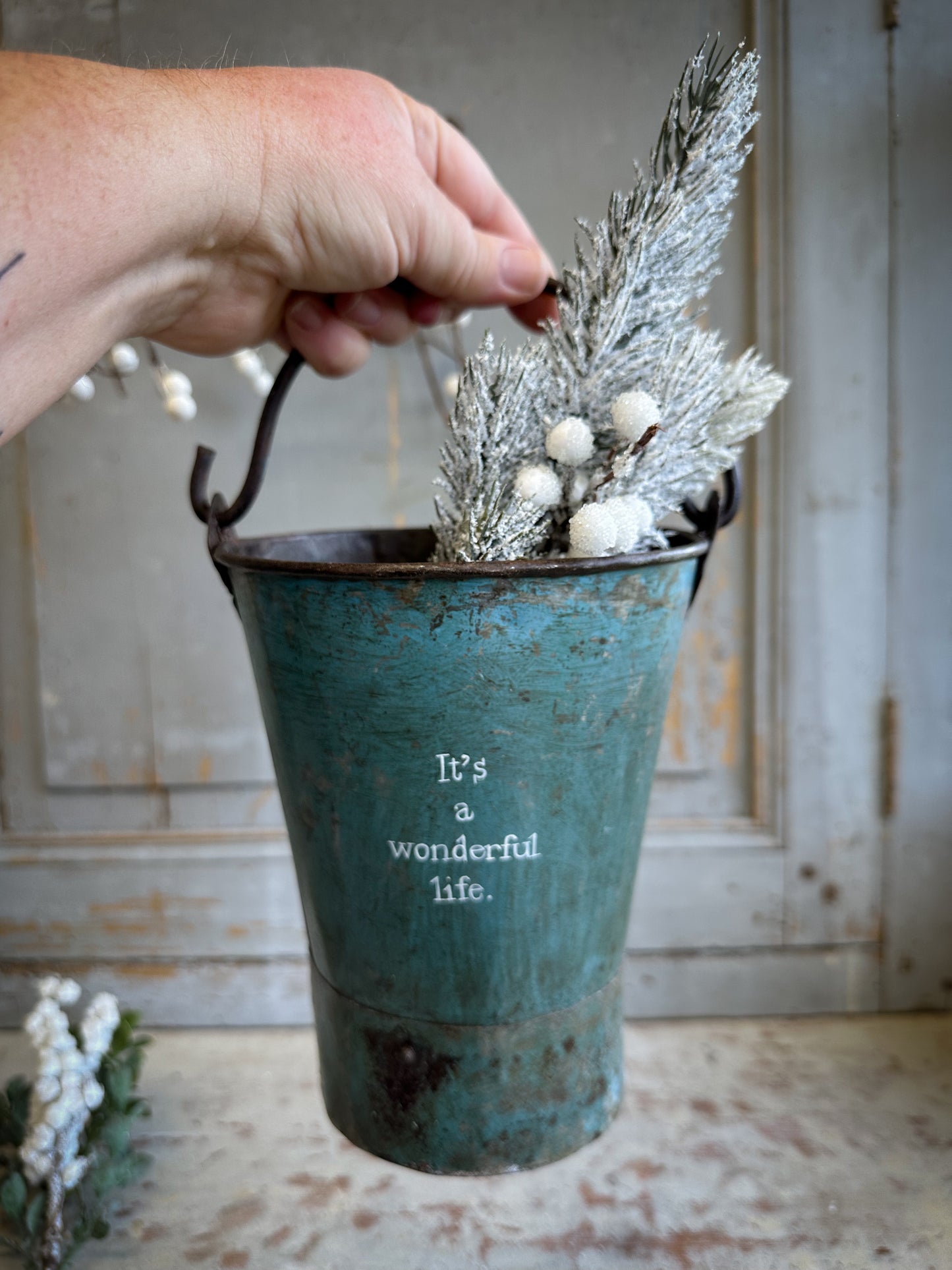A Recycled Metal Mini Christmas Tree Bucket With A Hand Painted Quote