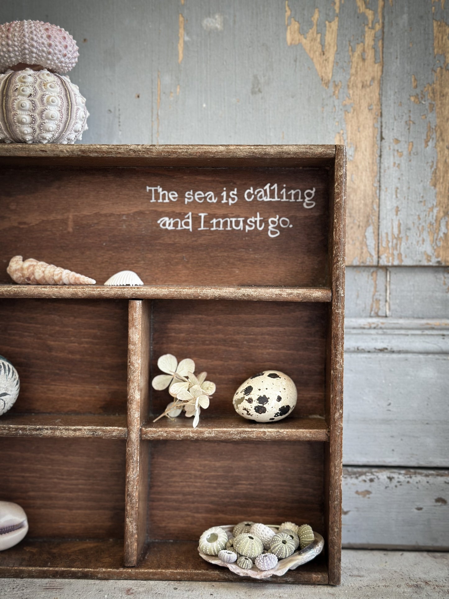 A Vintage Wooden Display Shelf With Hand Painted Quote