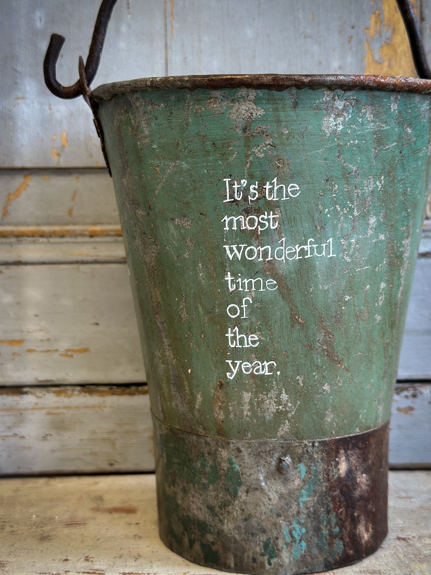 A Recycled Metal Mini Christmas Tree Bucket With A Hand Painted Quote