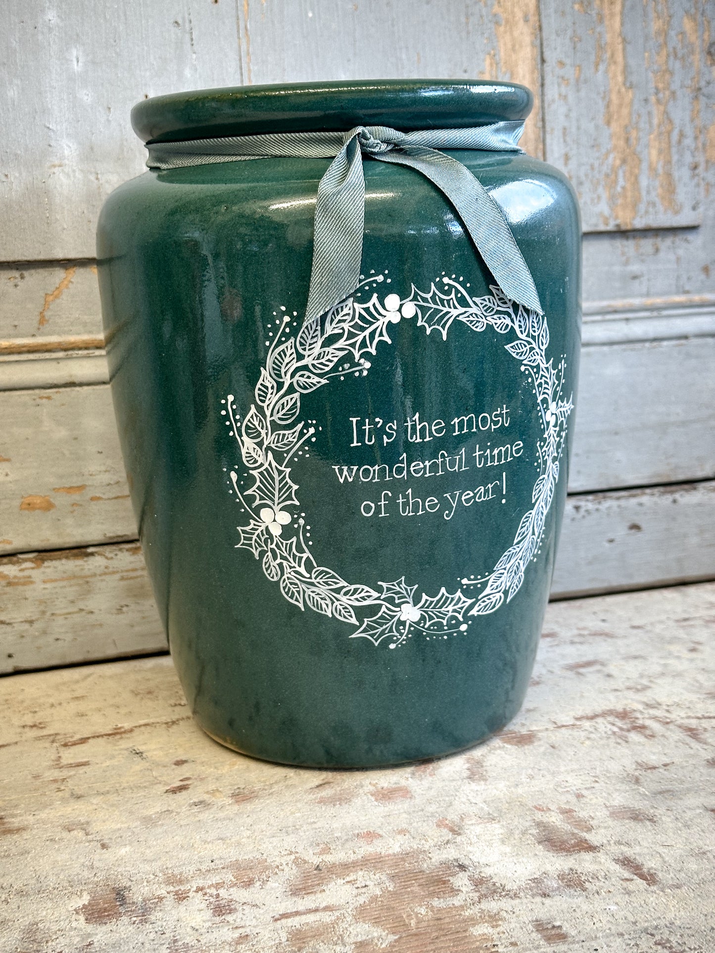 A large Emerald Green Antique Creamery Vase Bottle with a Hand Painted Wreath and Christmas Quote