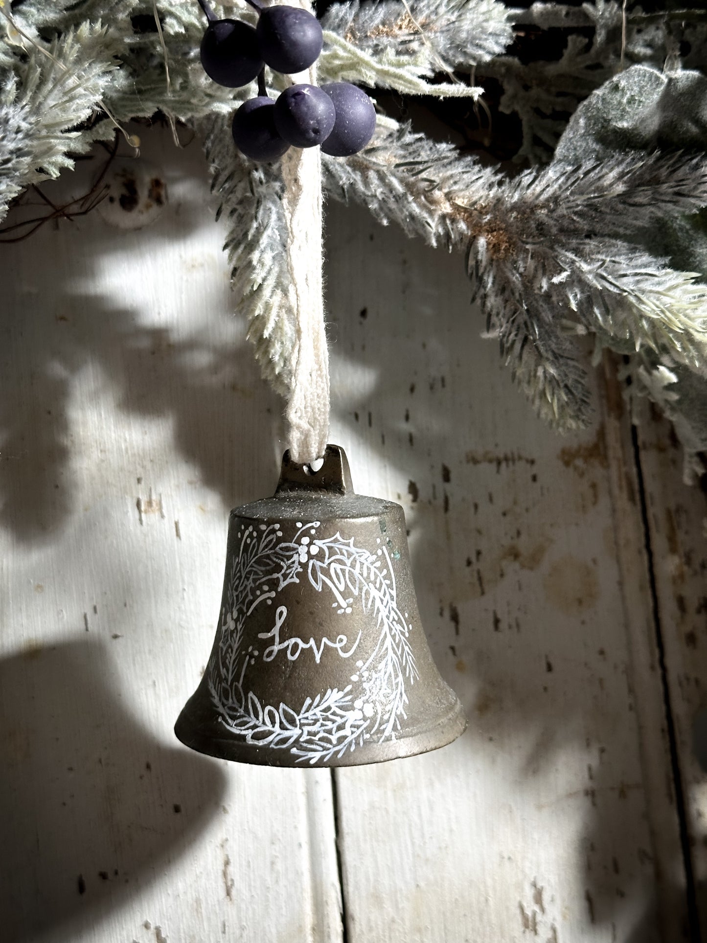 A vintage brass bell with a hand painted quote