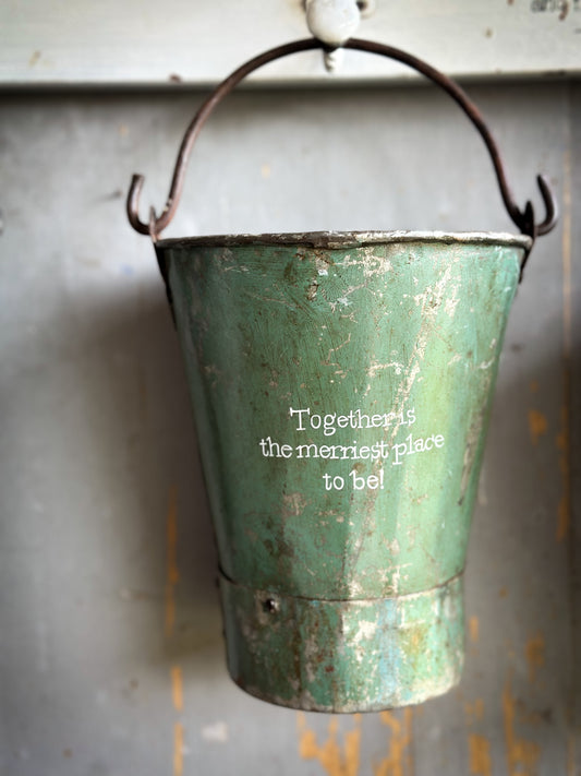 A Recycled Metal Mini Christmas Tree Bucket With A Hand Painted Quote