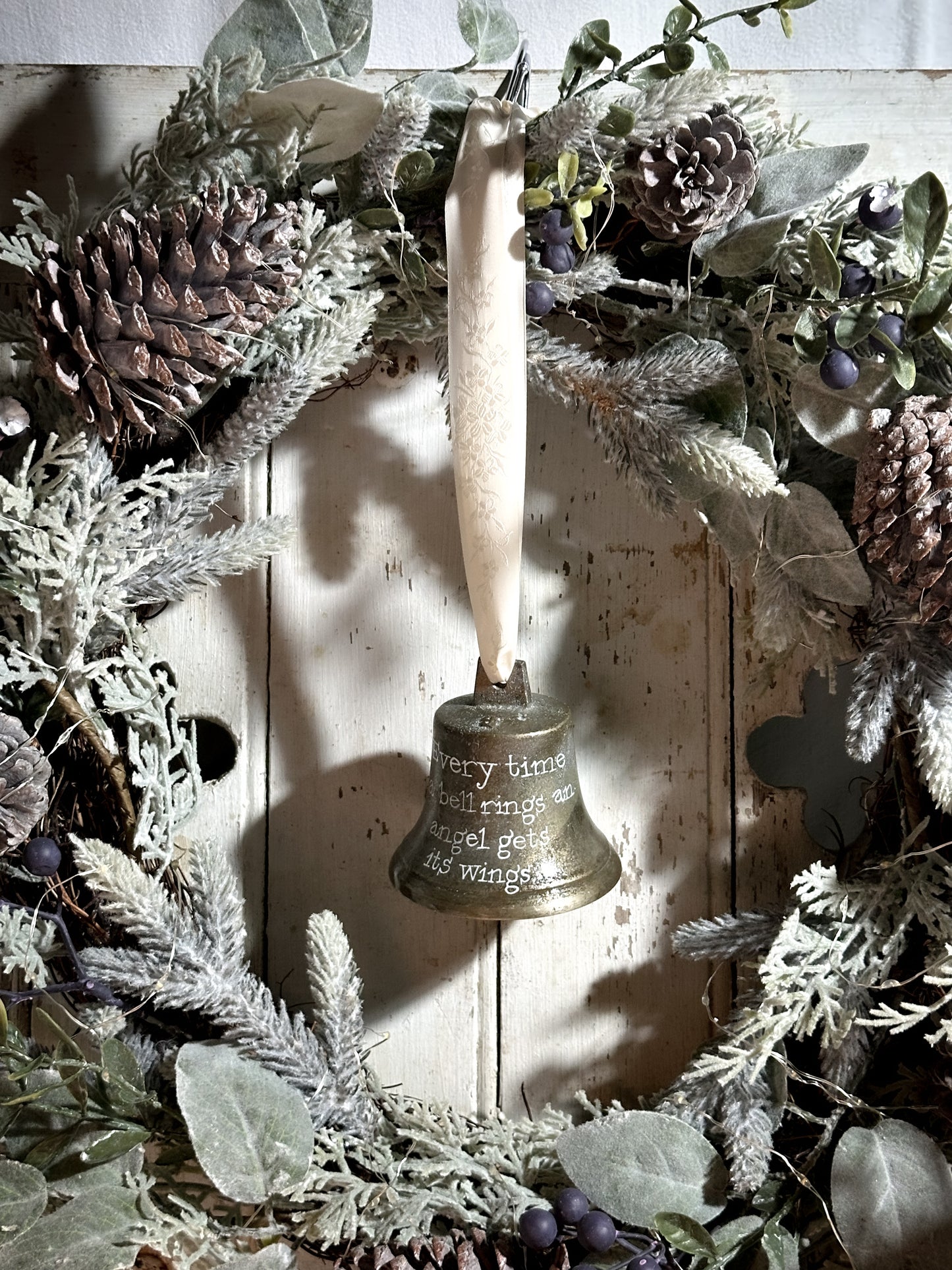 A vintage brass bell with a hand painted quote