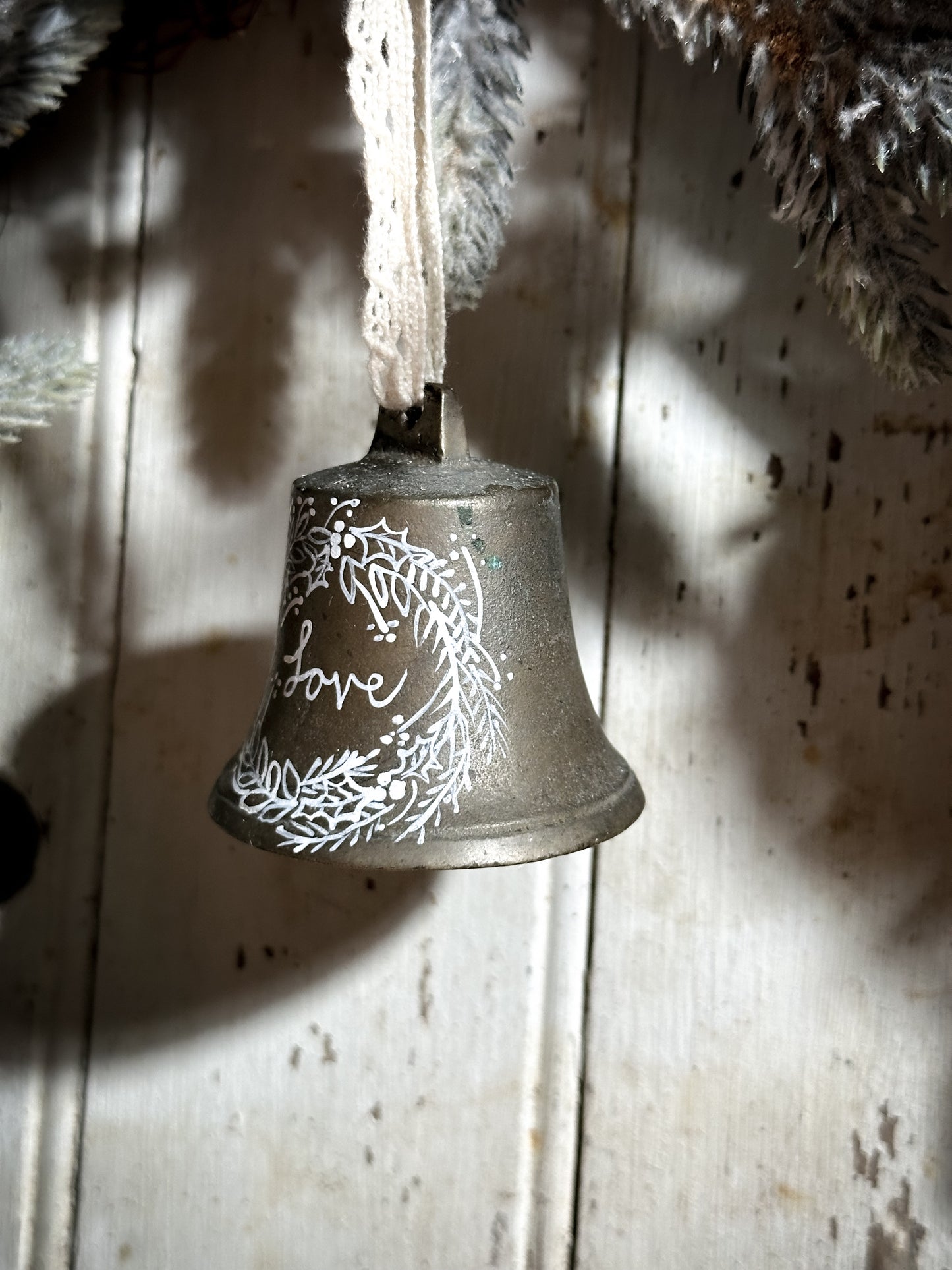 A vintage brass bell with a hand painted quote