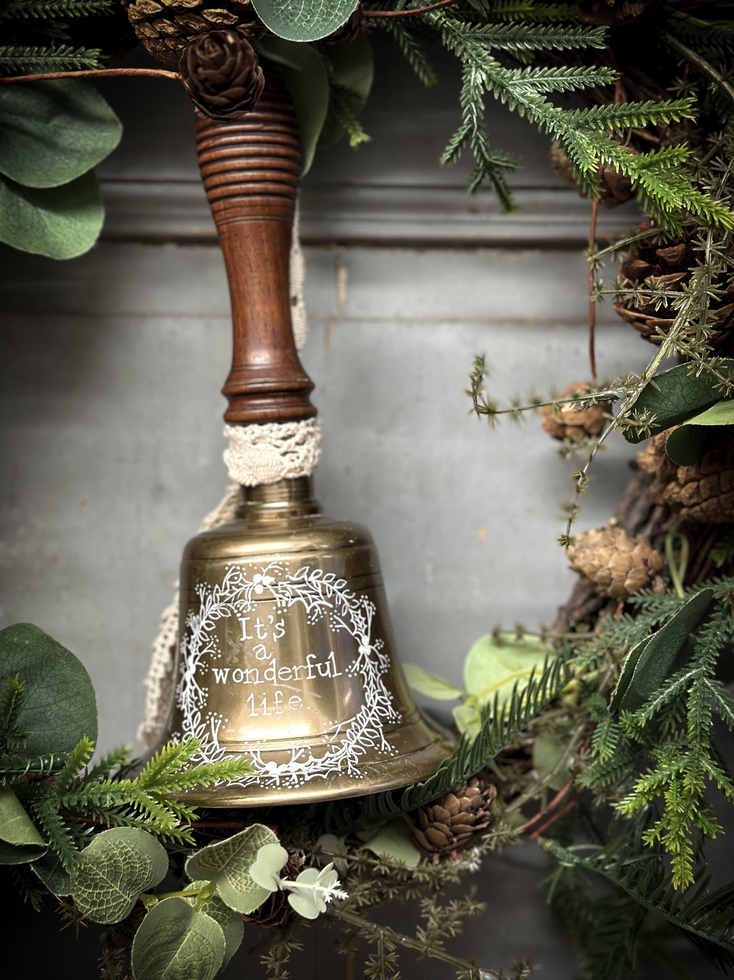 A vintage brass hand held bell with a hand painted quote