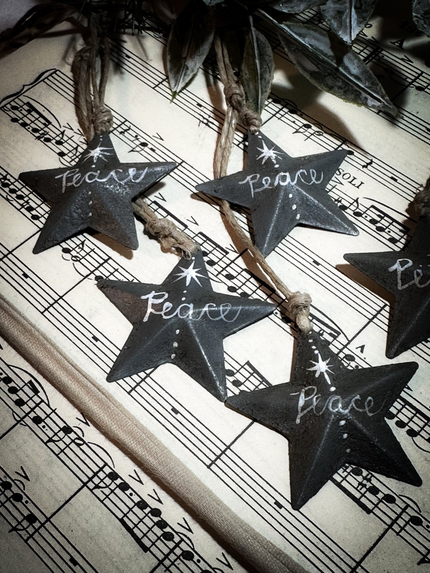 A mini tin barn star charcoal grey decoration hand painted with “Peace”