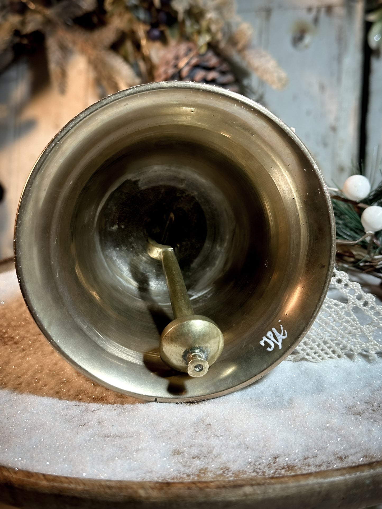 A vintage brass bell with a hand painted quote