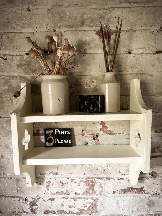 A pretty little painted wooden shelf with cut out detail